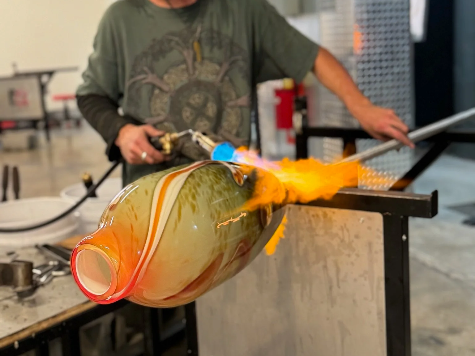 a man glass blowing with fire