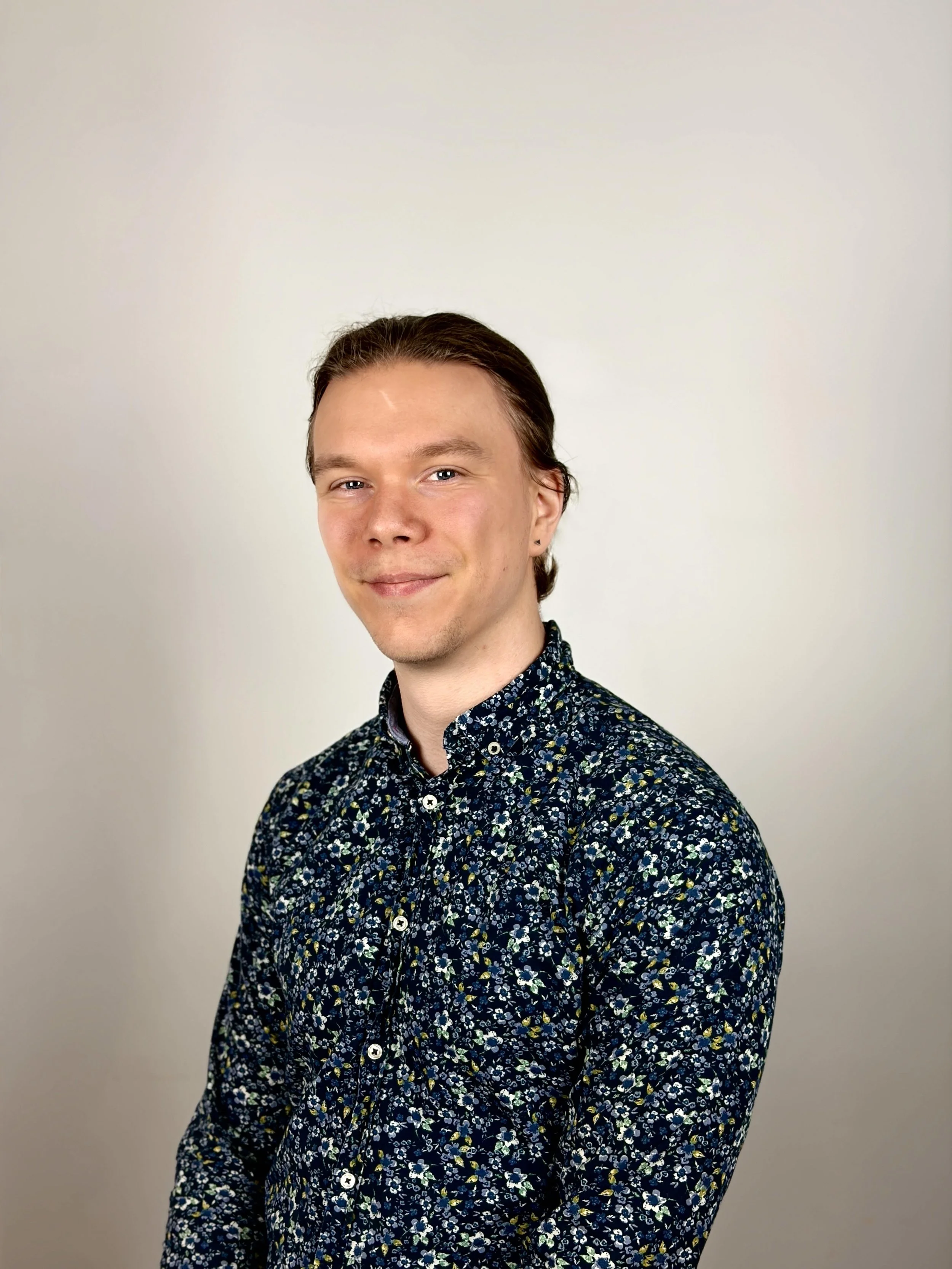 young man with blond hair wearing a nice button up shirt and smiling