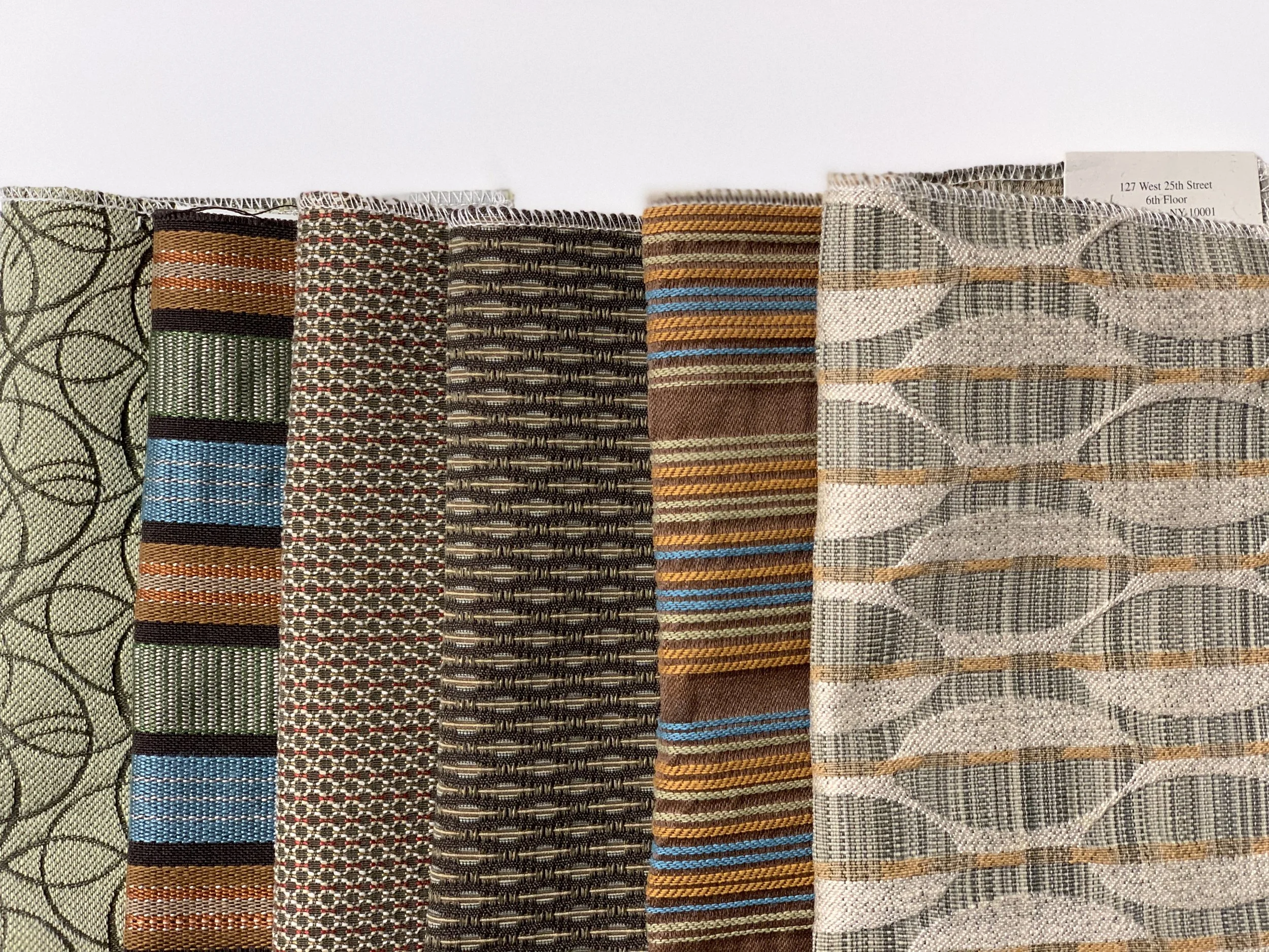 A row of fabric sample swatches with various geometric and striped patterns and colors.