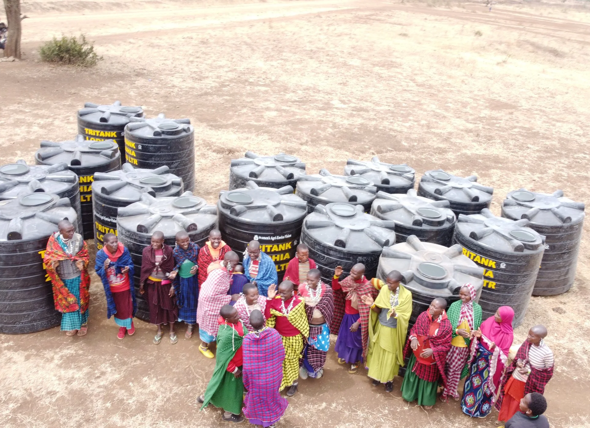 A group of women celebrating as they receive water tanks.