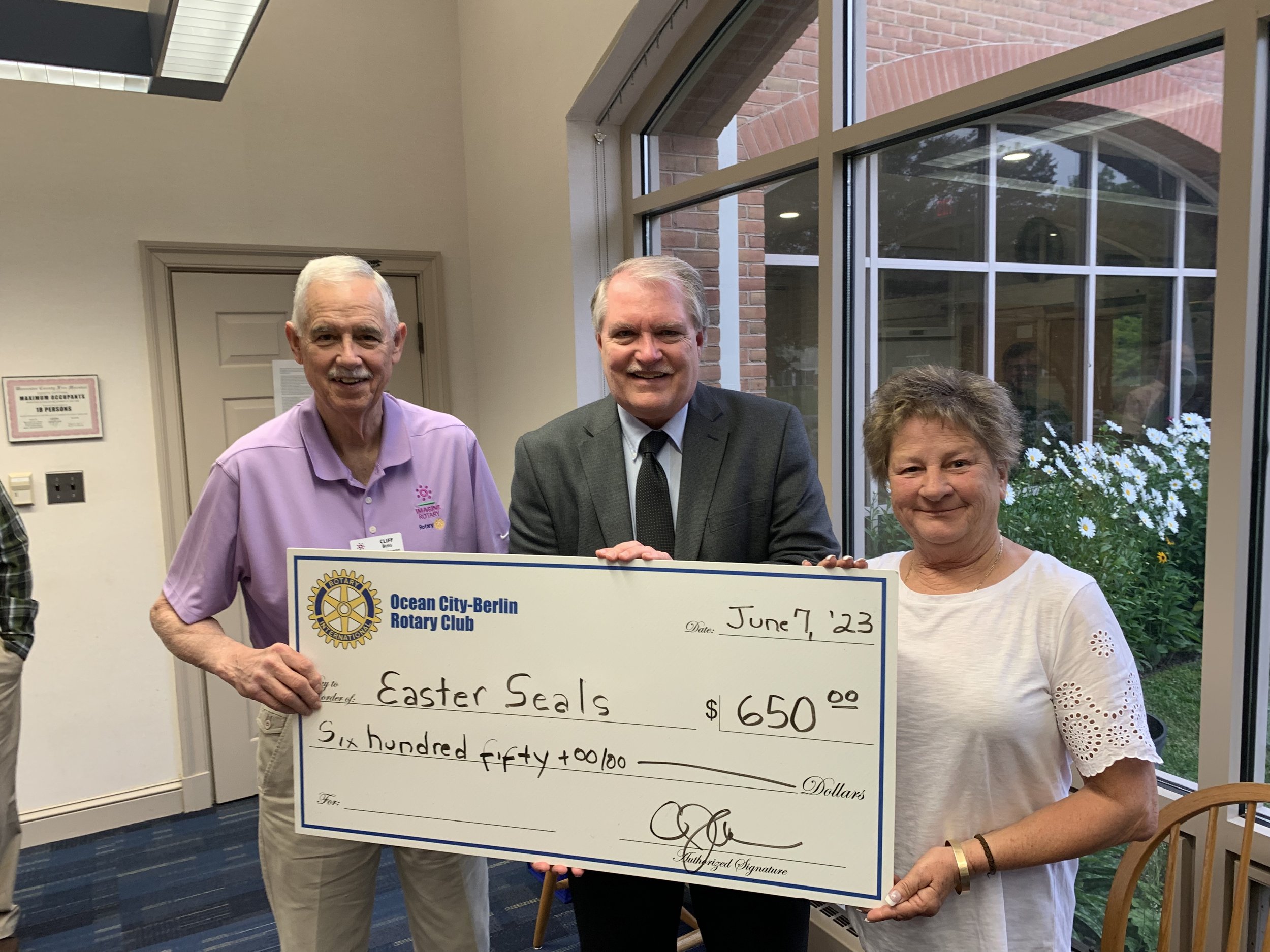  District Governor Cliff Berg (left) and Ocean City Berlin Rotary Club President Margaret Mudron (right) present a check to Ken Sklenar of Easter Seals. 