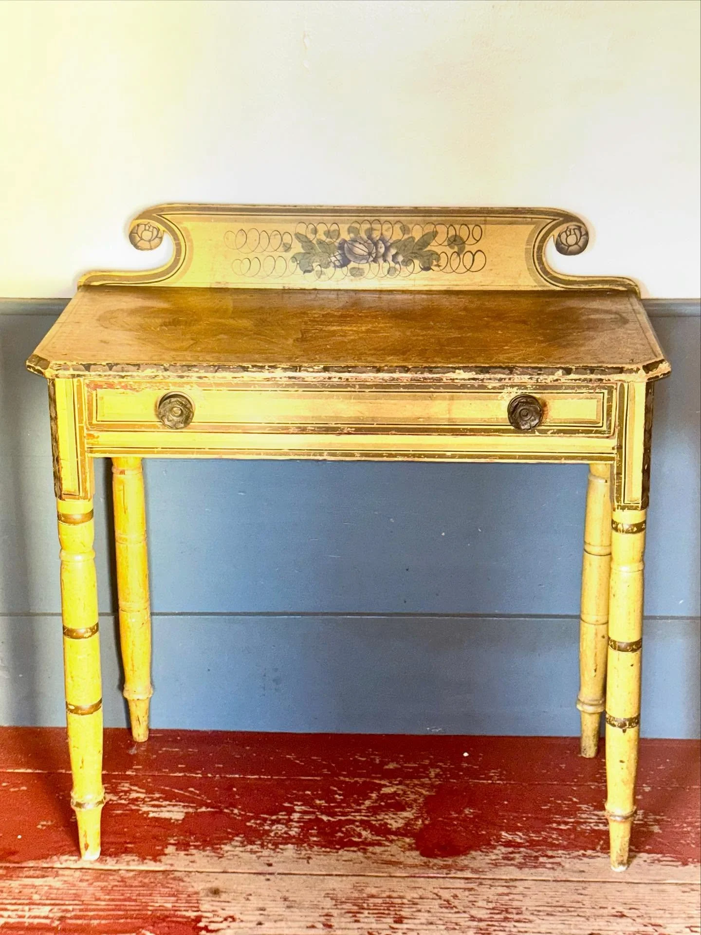 This New England yellow-painted dressing table, dating to the 19th century, embodies the warmth and simplicity of early American craftsmanship. 

It retains its original mustard-yellow paint, softly aged to a warm patina. The turned legs and hand-cut