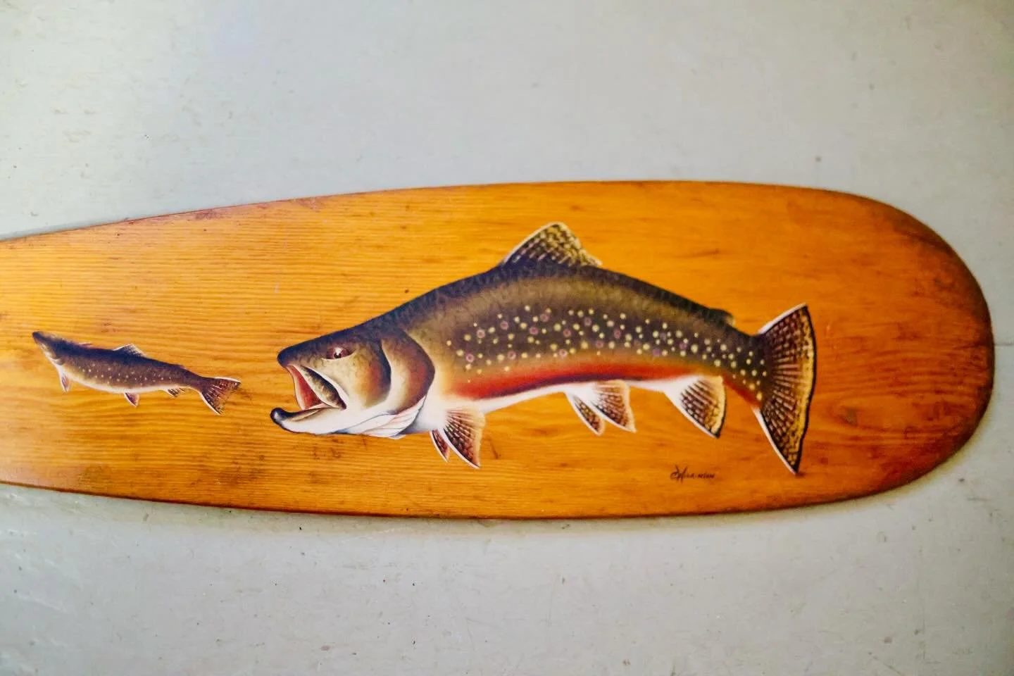 Hand-painted in the late 1990s and signed by C. Wilkinson, this wooden Old Town canoe paddle is a &lsquo;striking&rsquo; example of folk art with a sporting theme.

Rendered in rich, realistic oil-on-wood, this detailed trout reflects a deep apprecia