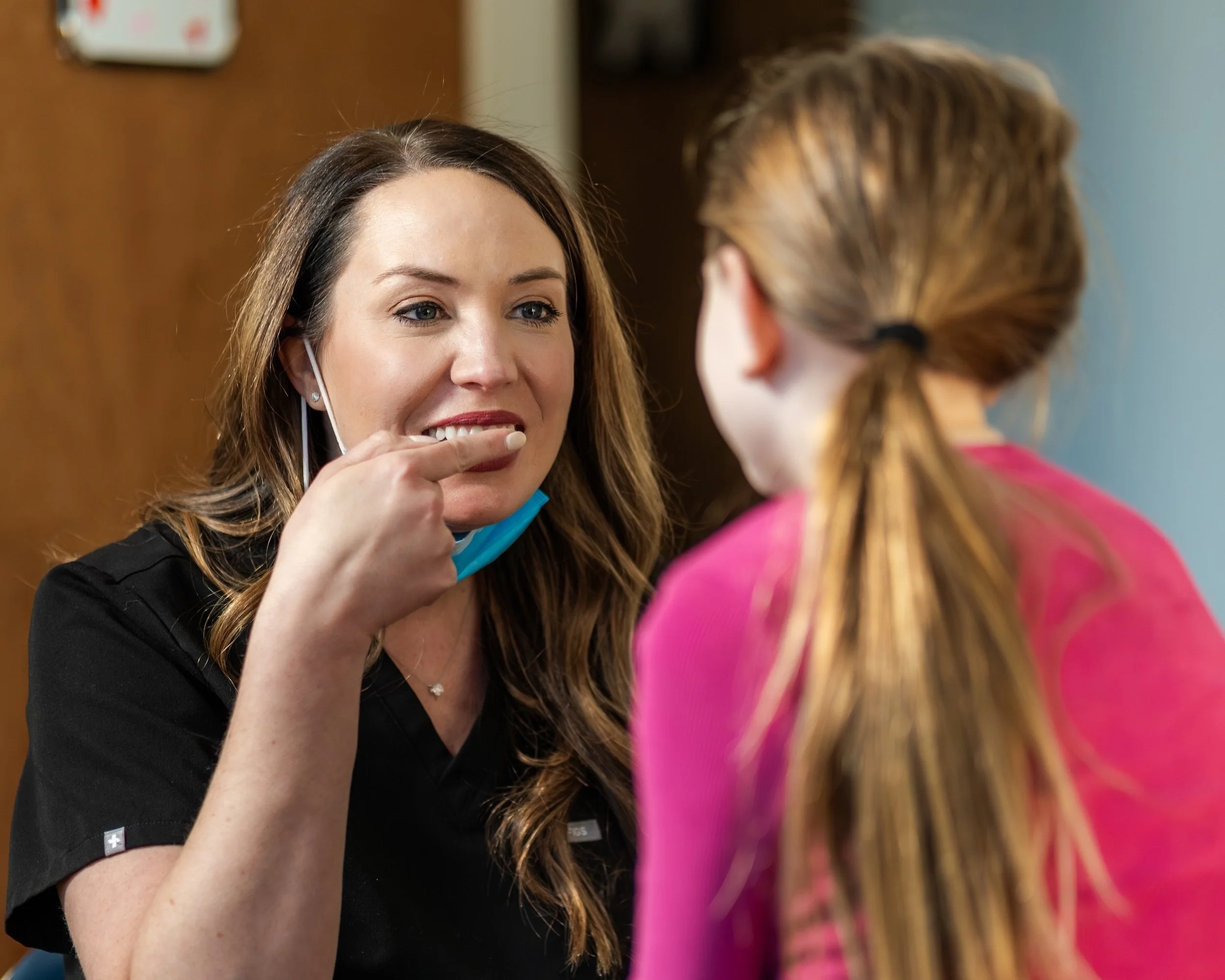 Conway pediatric dentist Stefanie Meek showing a child how to brush her teeth