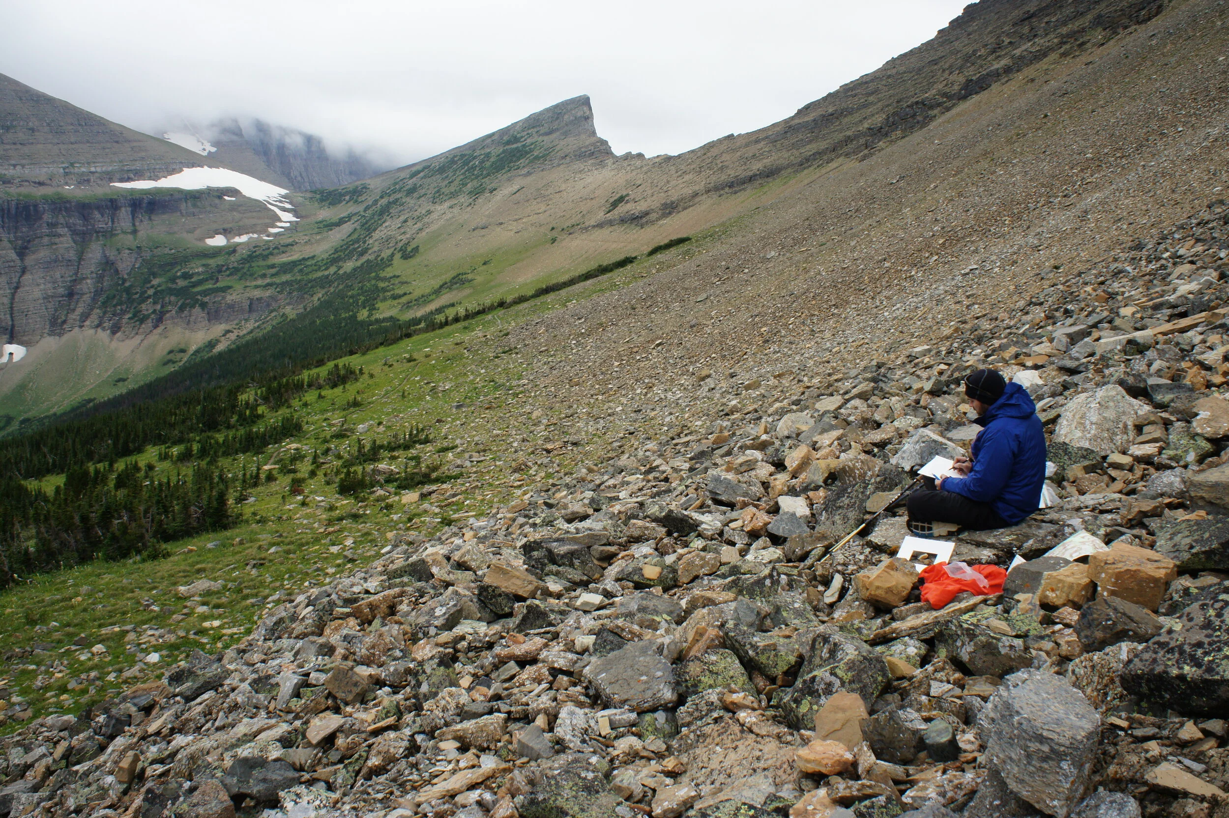  Todd Anderson sketching in Glacier National Park under a threatening sky. When circumstances do not allow for travel on the glacier itself I will often hike up a corresponding mountainside to gain elevation and a better view of the particular glacie