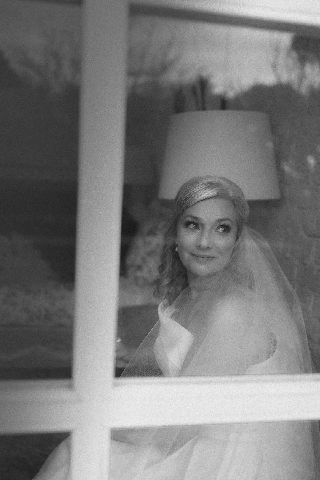 Romantic winter bride gazing through a window