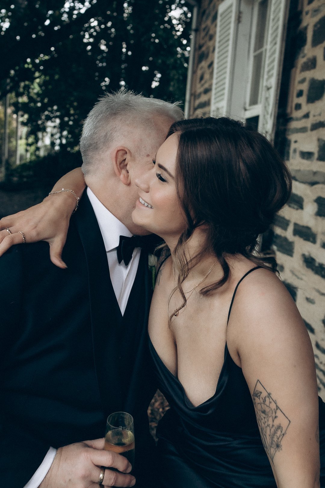 Daughter with elegant updo hugging her father, the groom