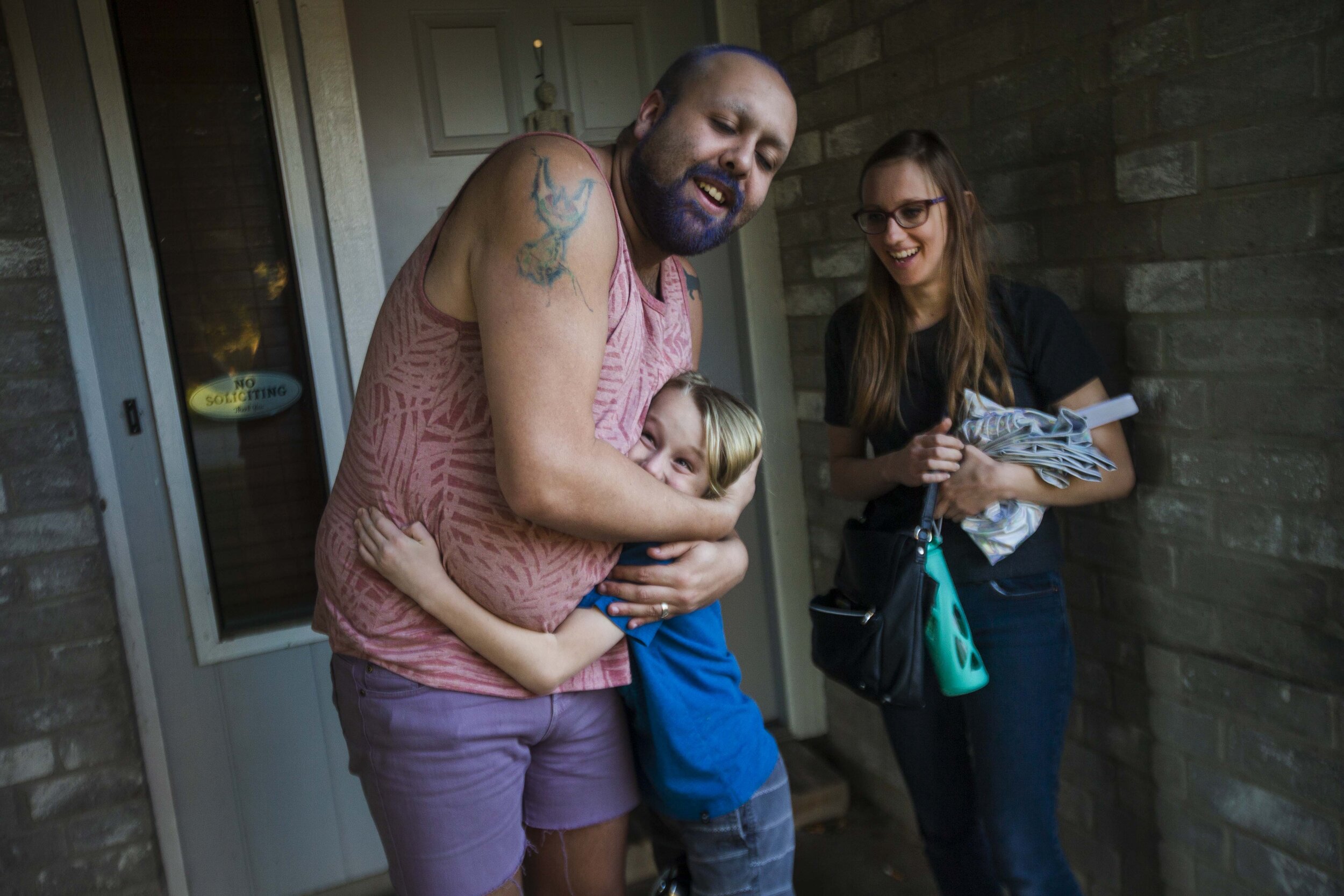  Robby, a drag queen, then 25, left, embraces Keegan, a gender creative child, then 8, middle, as Keegan's mother Megan, then 32, looks on following a rehearsal for Keegan's upcoming inaugural drag performance at the home Robby shares with his husban