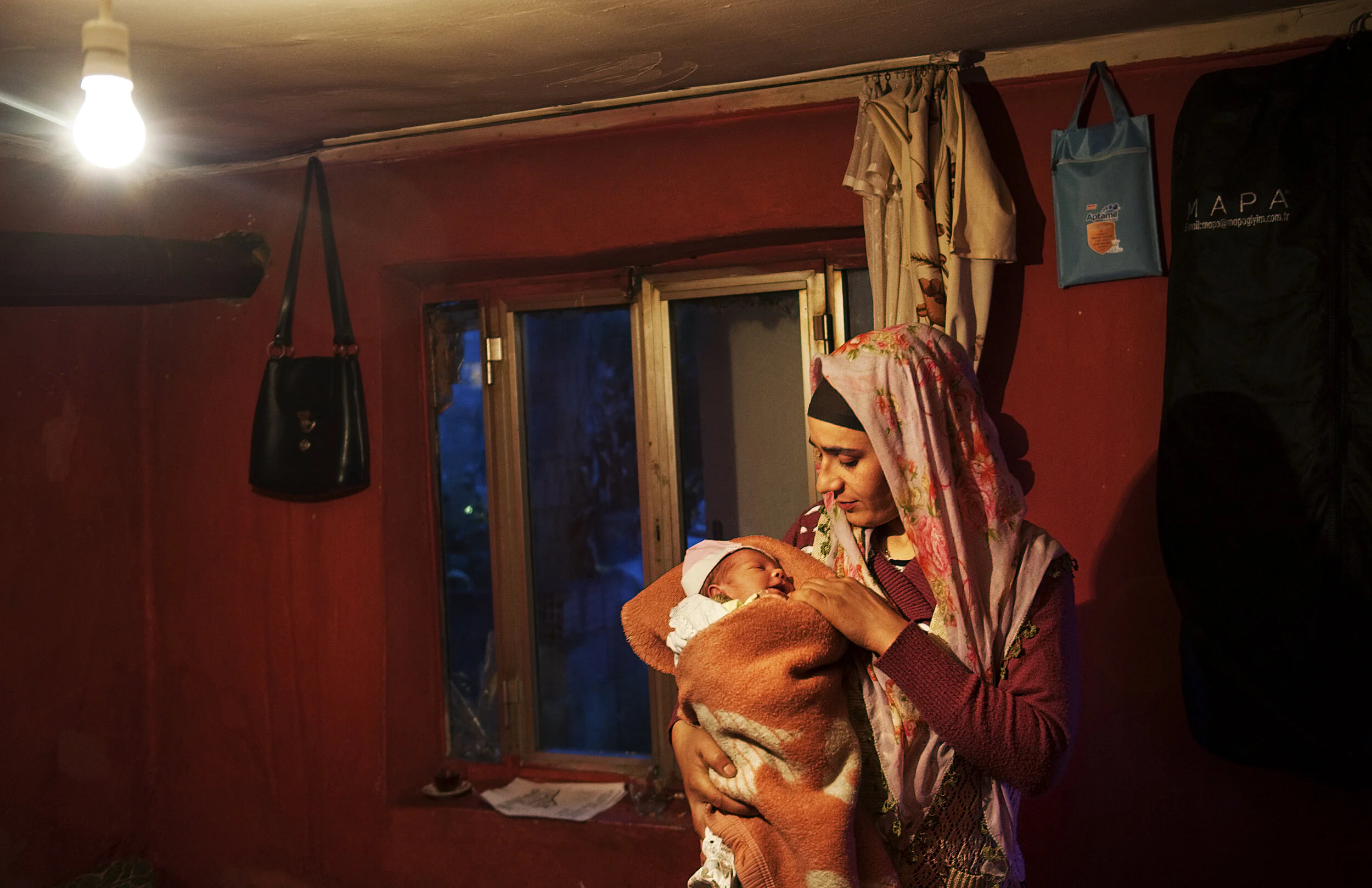  Selcan Kesman comforts baby Remzi, during the early evening hours at in the flat she shares with her sister-in-law 