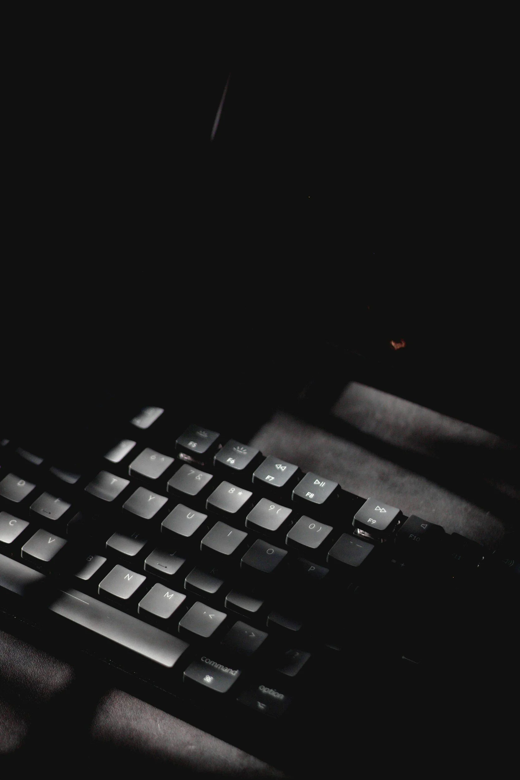 Close-up of a illuminated computer keyboard in a dark room.