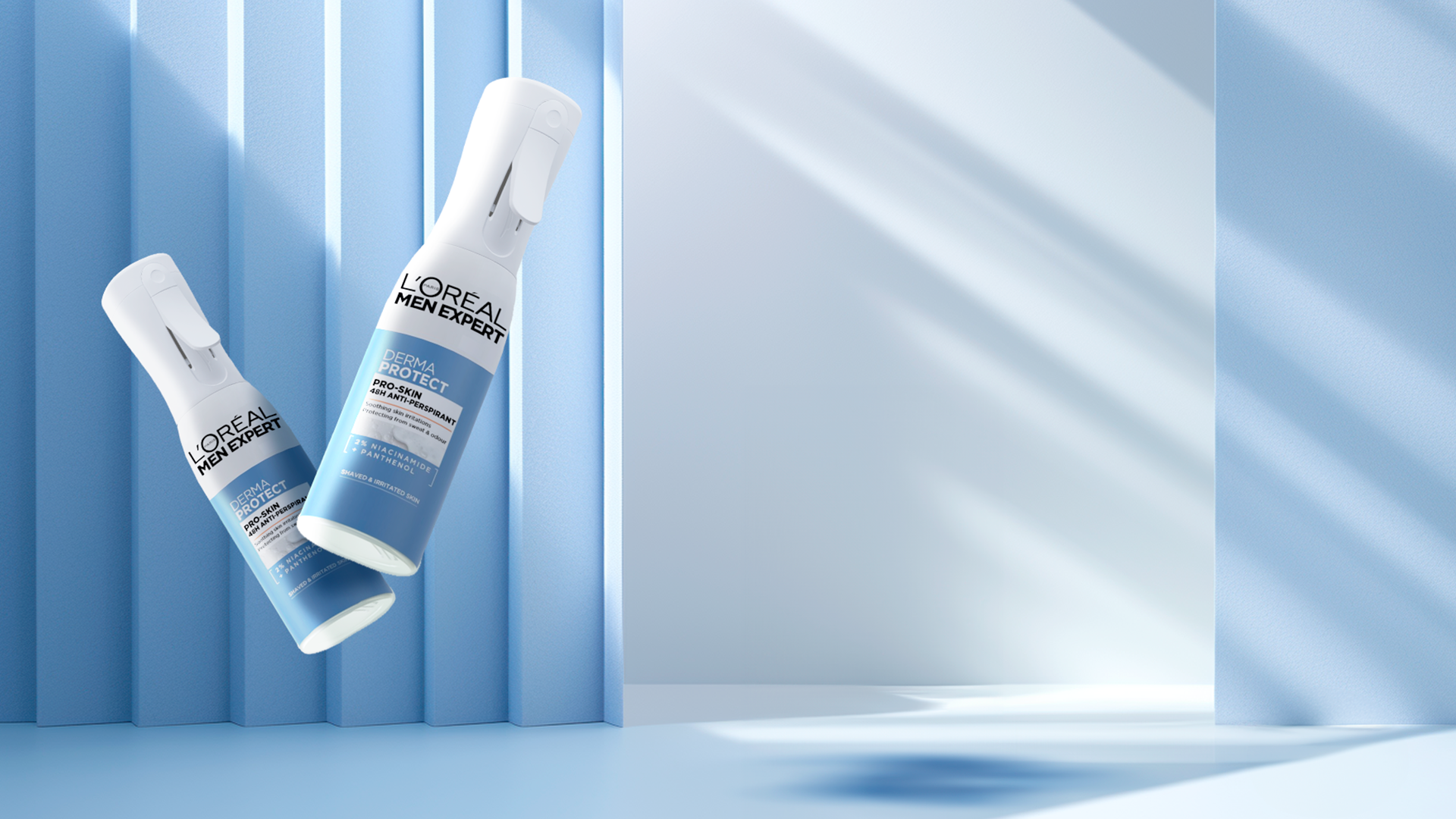 Deux sprays de déodorant L'Oréal Men Expert Derma Protect en suspension dans un décor bleu avec des rayons de lumière, devant un mur bleu et un miroir.