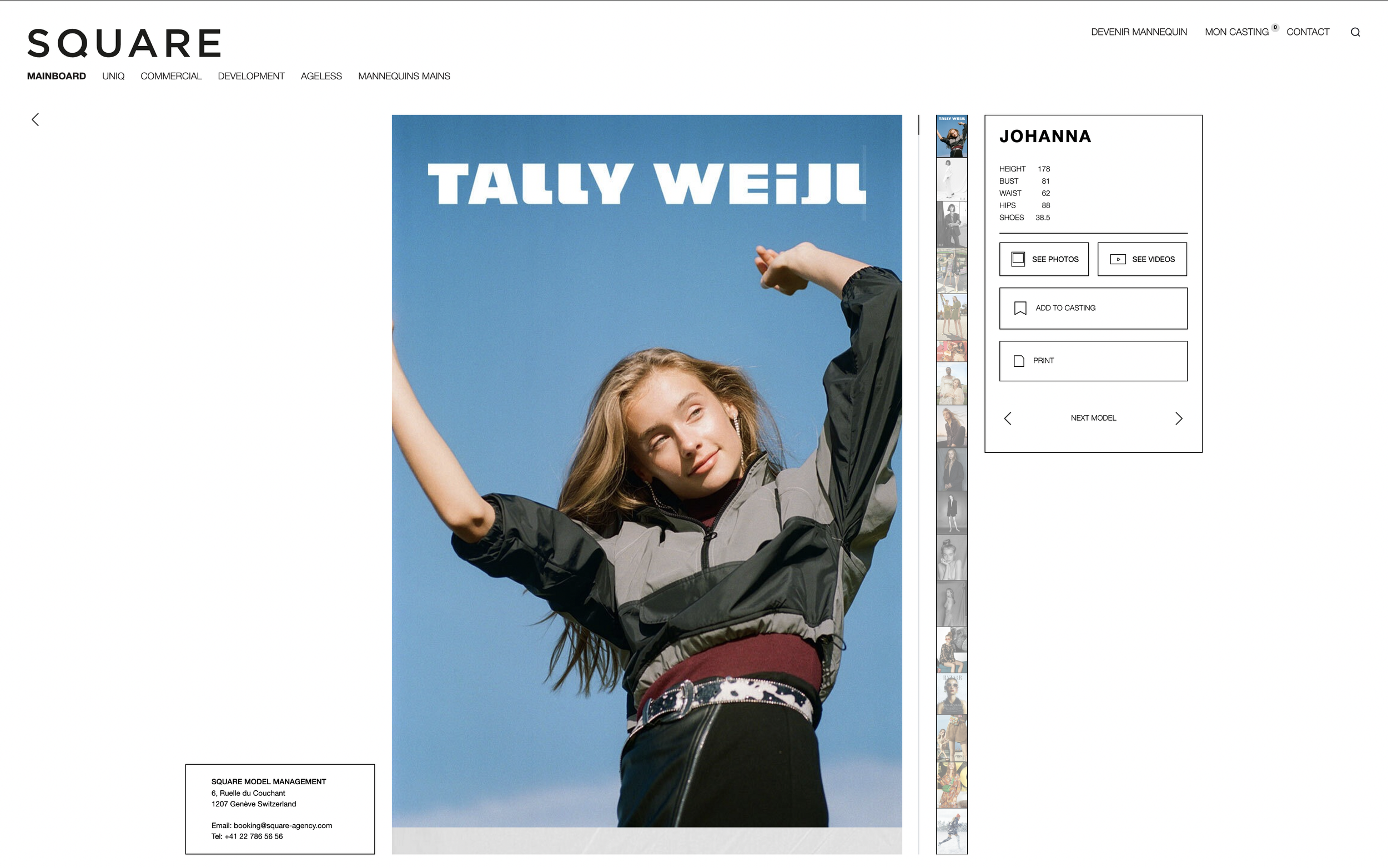 Une jeune femme pose avec ses bras levés contre un ciel bleu, portant une veste de sport gris et noir, vêtue d'un t-shirt noir et d'un pantalon noir avec une ceinture à motifs.