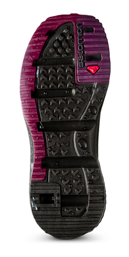 Semelle de chaussure de sport SALEWA, conçue pour la randonnée ou le trail, avec crampons en caoutchouc noir, accents roses et une petite pompe à air pour ajuster la compression.