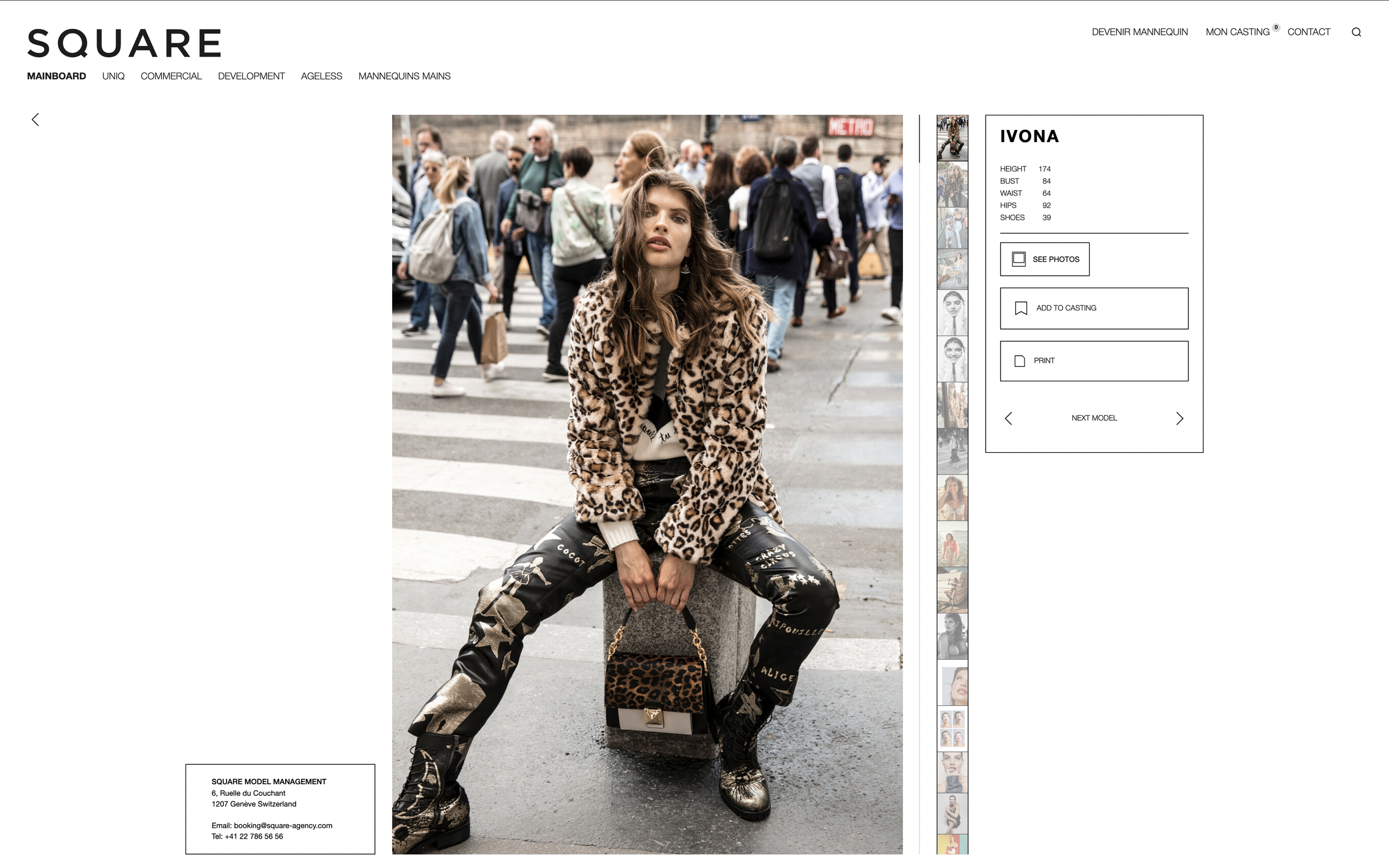 Une femme en tenue à motifs léopard pose assise sur un banc au croisement, entourée d'une foule dans une rue de ville.