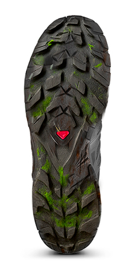 Semelle d'une chaussure de randonnée en caoutchouc avec des crampons et des accents verts