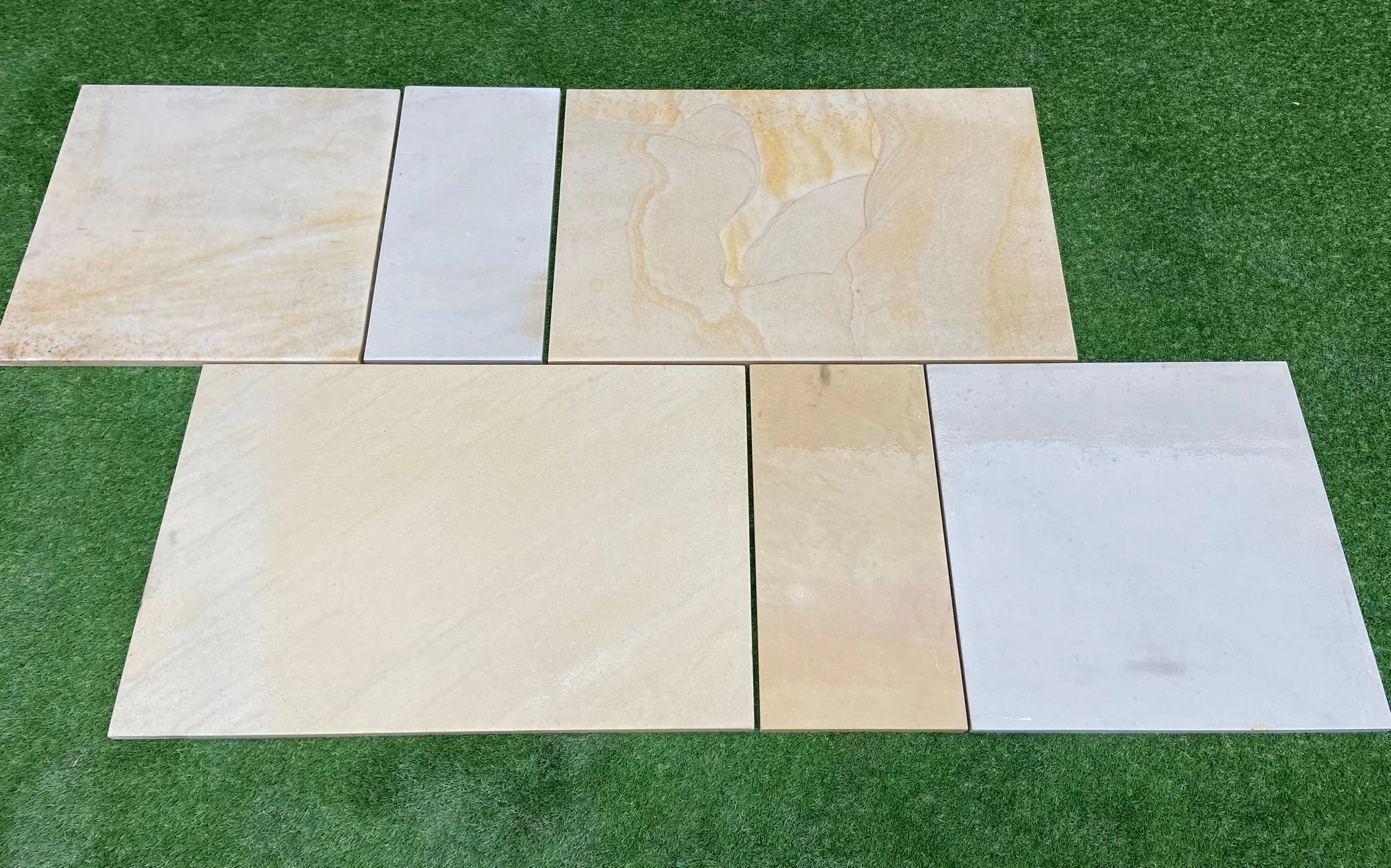 Image of our Buff Sandstone Paving laid on grass showcasing the sizes of slab available from Shanlieve Stone from their Yard in Newry, Northern Ireland 