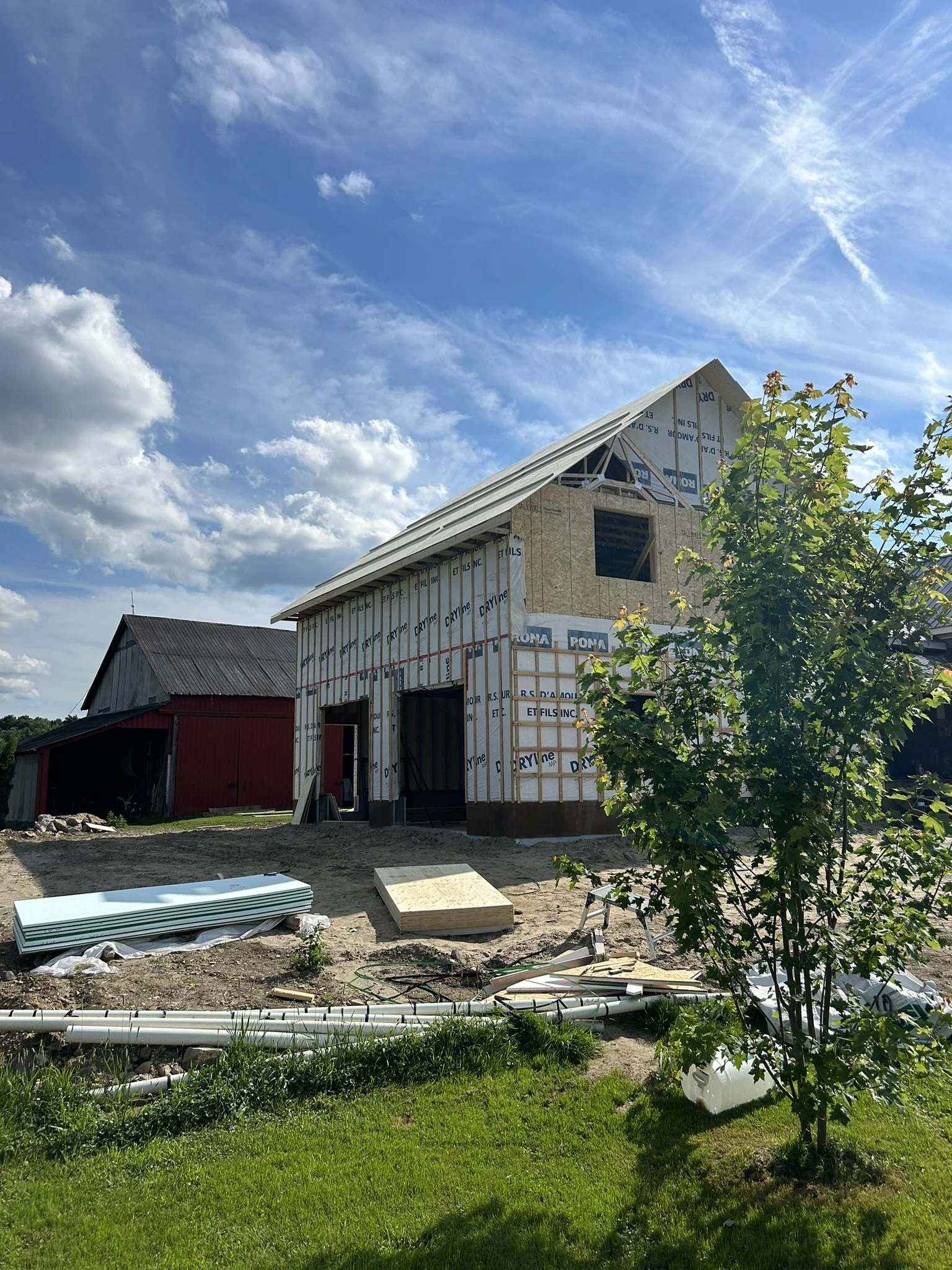 Construction progress of 900 square foot farmhouse addition showing exposed beams and framing