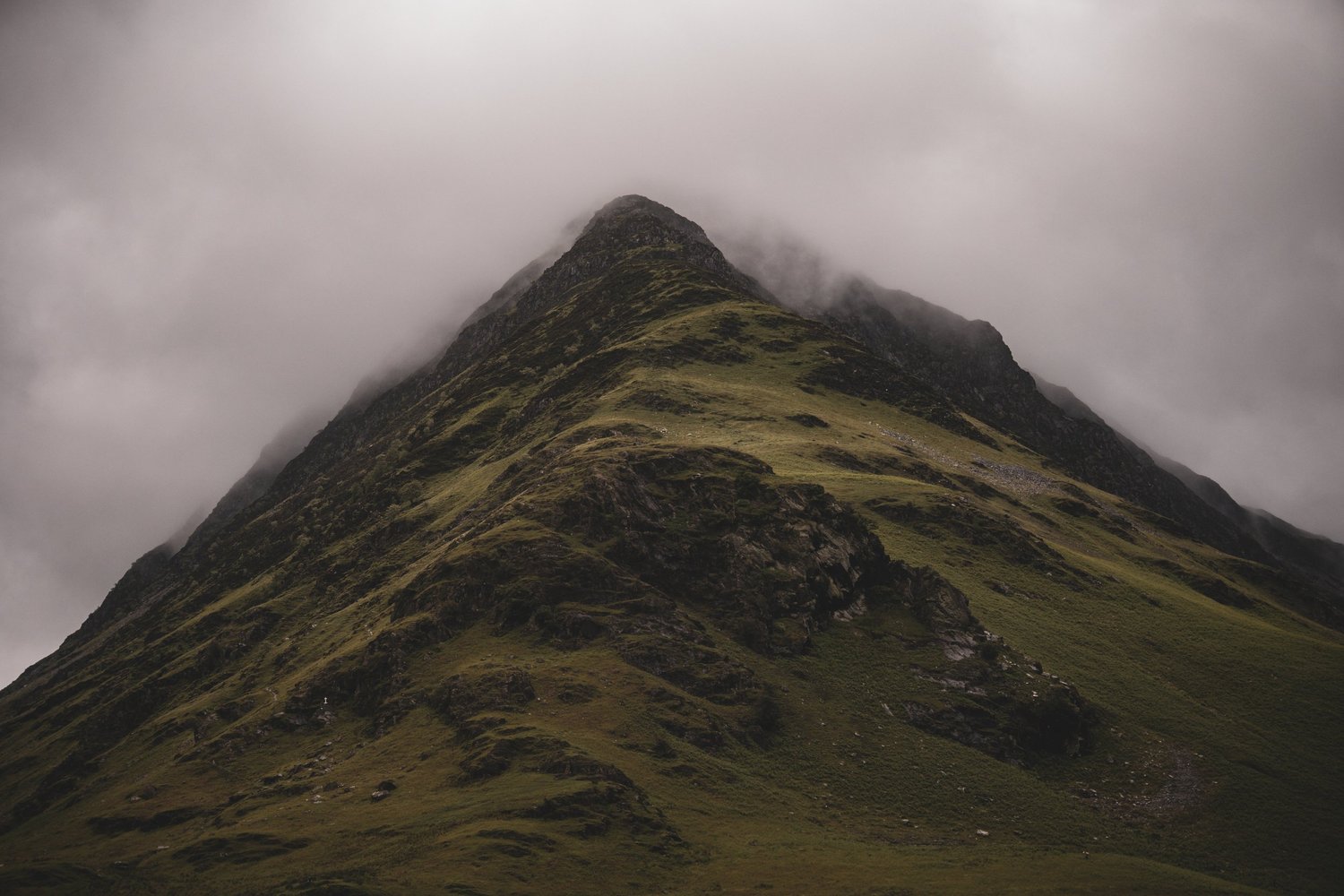 A mountain ridge disappearing into low cloud, photographed by Joshua Ball