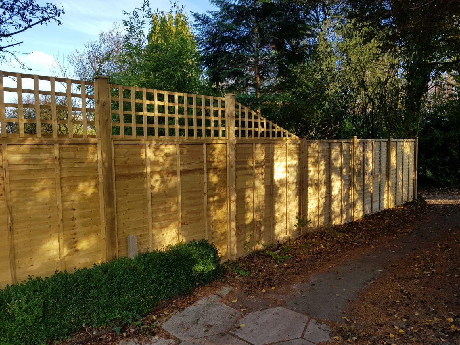 Overlap fence panels with trellis over Winterbourne.jpg