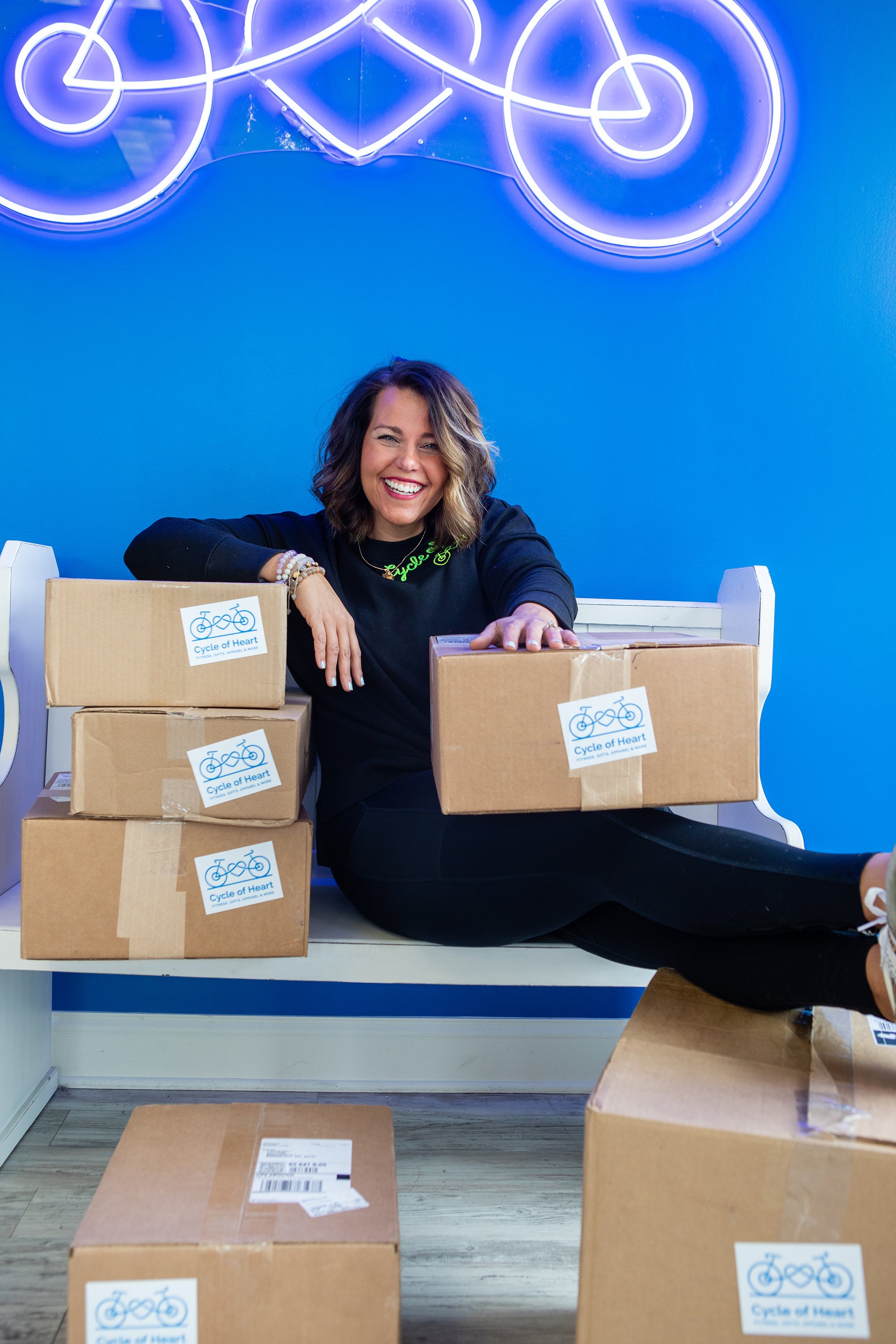  lady smiling with boxes stacked around her 