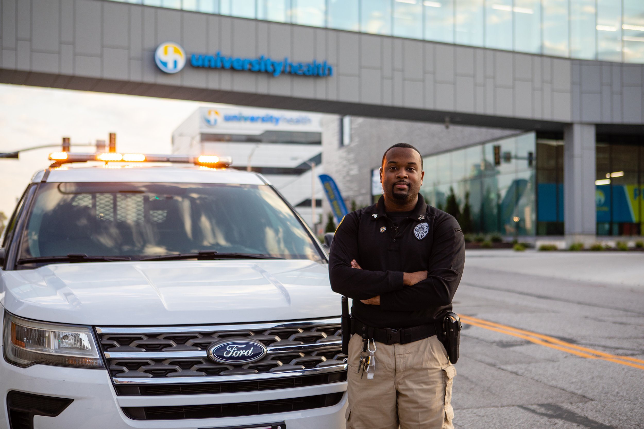  university health officer standing by patrol car under walkway 