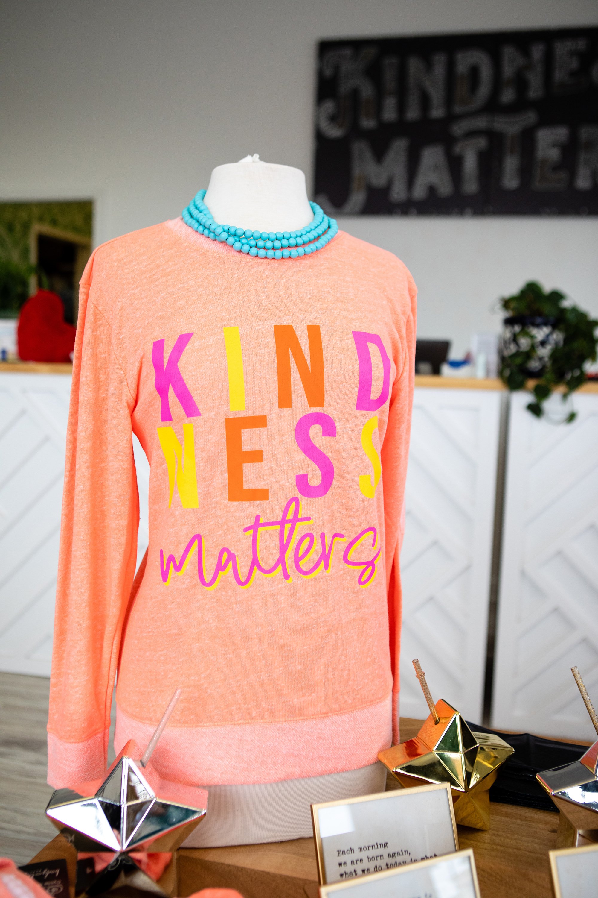  kindness matters shirt in store front setup 