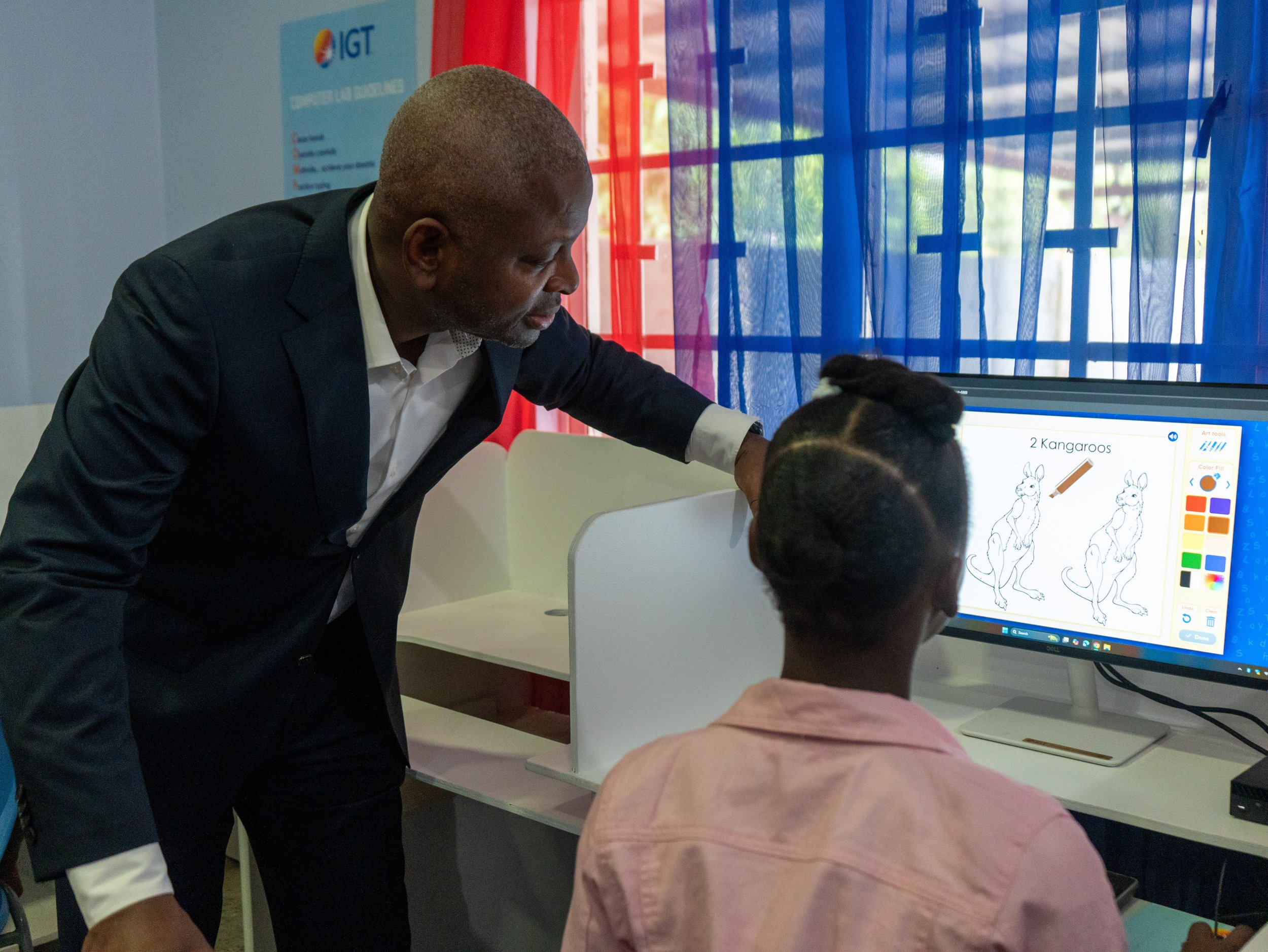 Dexter Thomas, IGT General Manager Trinidad and Tobago, helps this young lady with an ABCmouse digital lesson on the new desktop at Casa de Corazon Children’s Home.