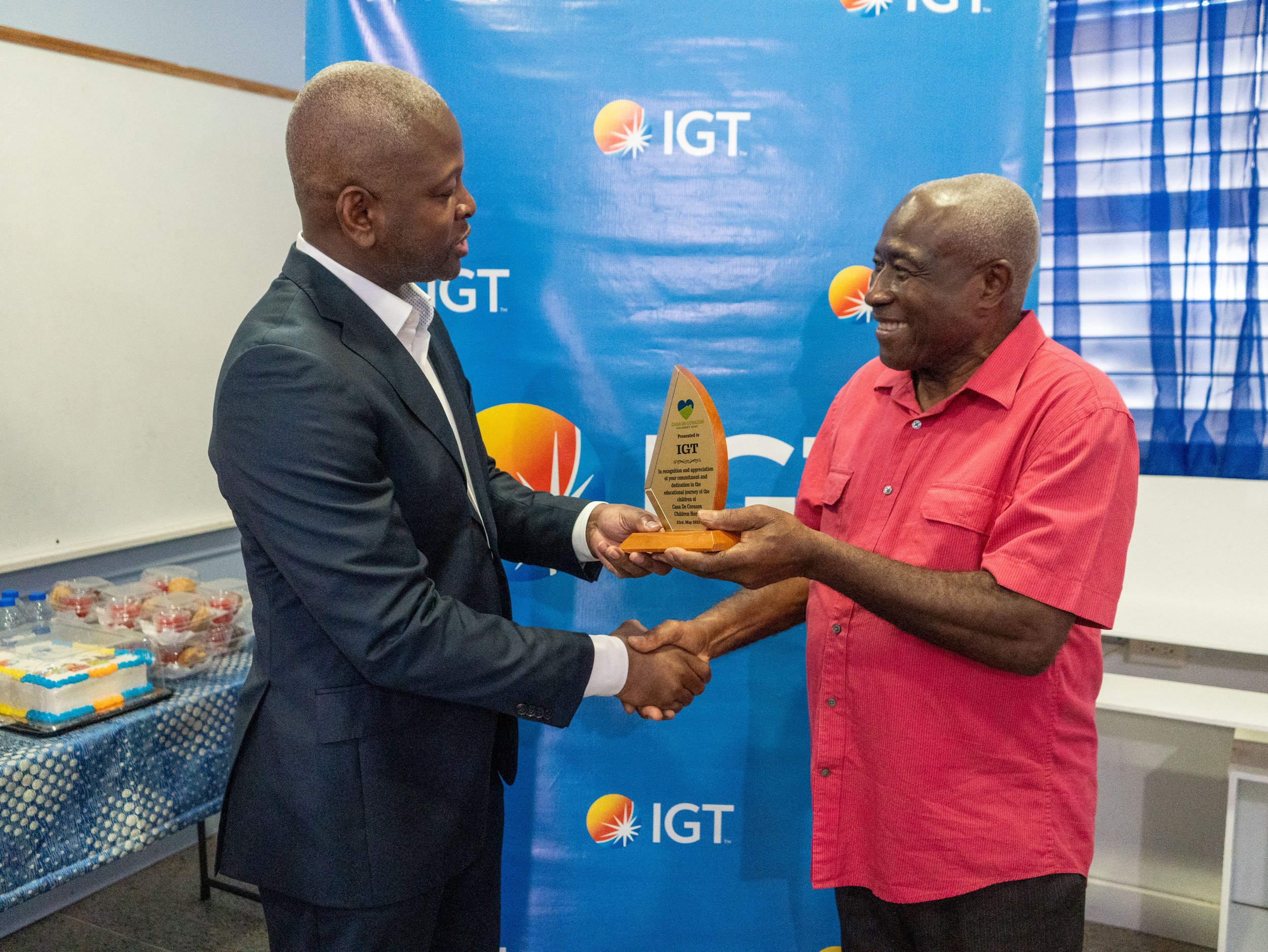 Dexter W. Thomas, IGT’s General Manager Trinidad and Tobago, receives a token of gratitude in recognition of the company’s longstanding partnership with Casa de Corazon from its Chairman, Pastor Peter Morris.