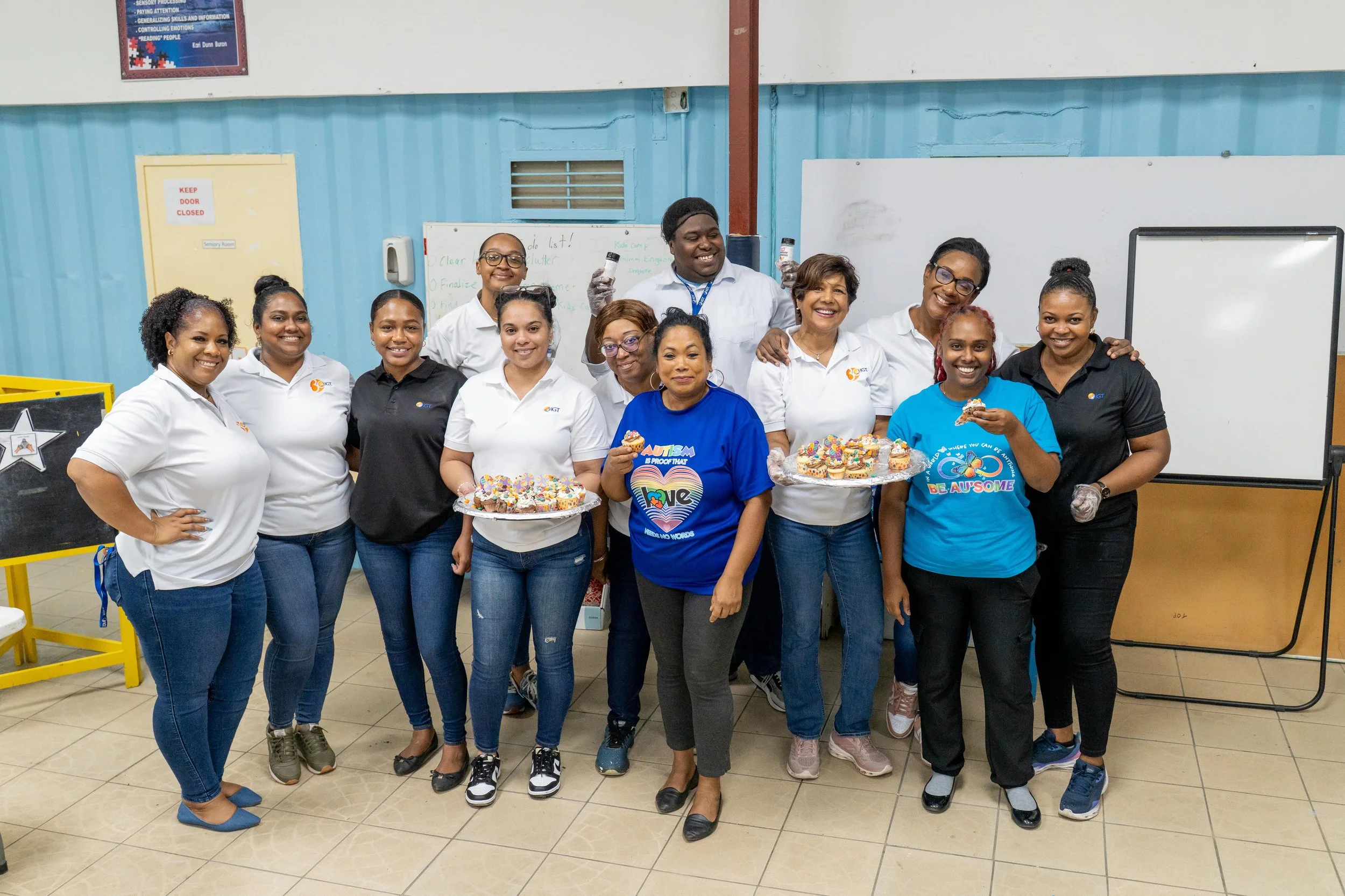IGT volunteers join Amoy Raymond (centre in blue) to display cupcakes they baked and decorated with the Autism Society of T&T’s Adult Recreation Group as part of IGT’s Global Giving Month activities on 16th May.
