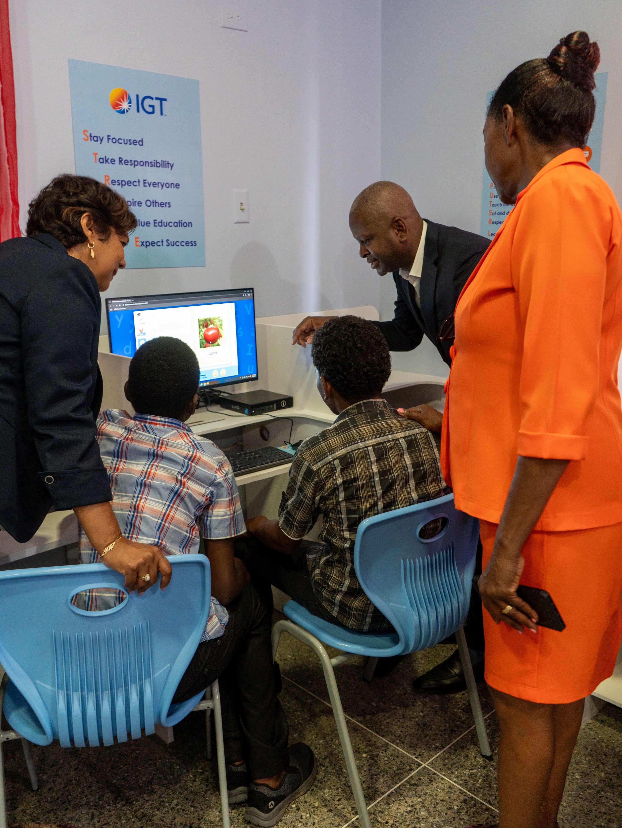 Dexter Thomas, IGT General Manager Trinidad and Tobago, helps this young lady with an ABCmouse digital lesson on the new desktop at Casa de Corazon Children’s Home.