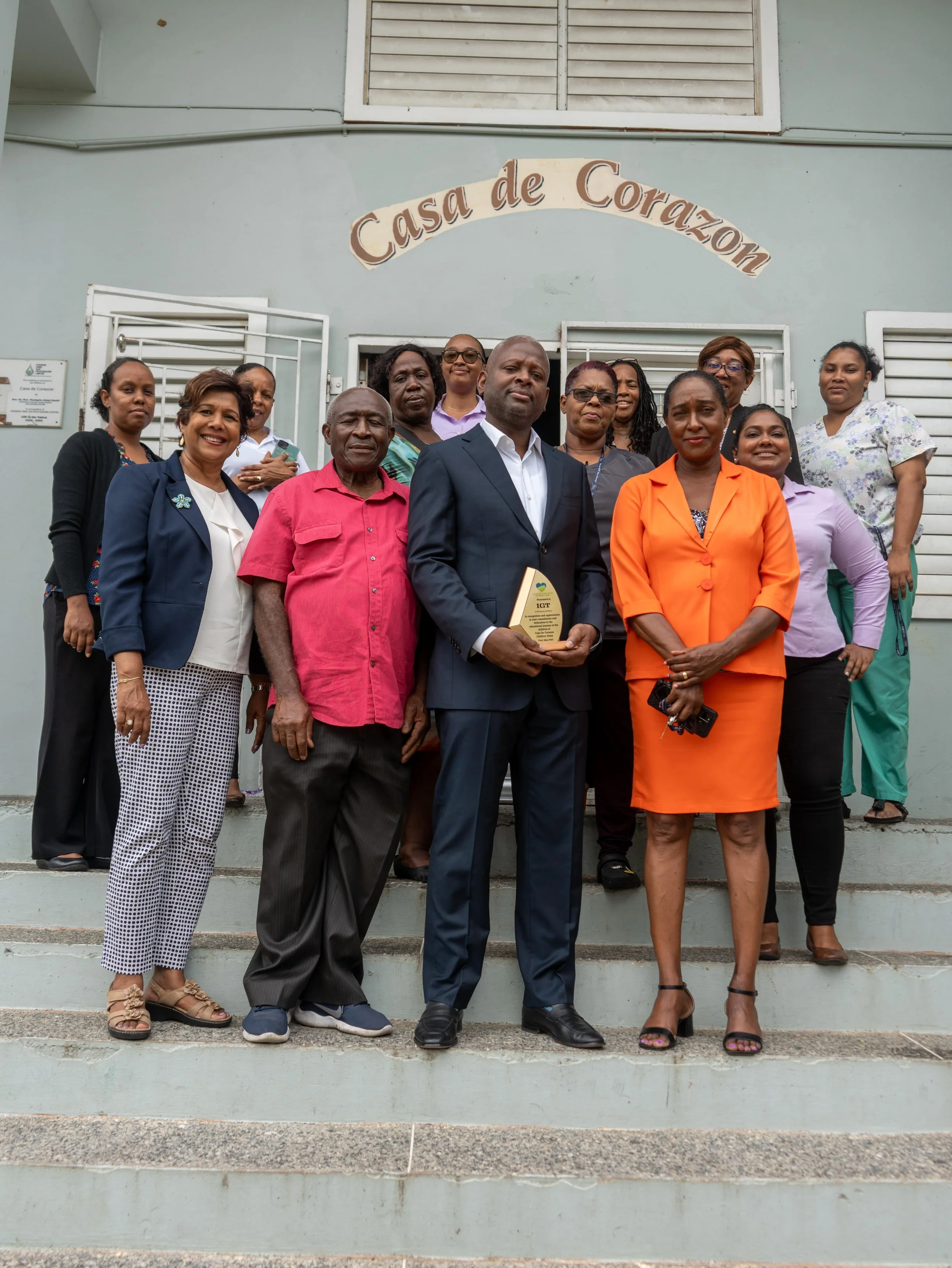 (Front row, left to right) IGT People & Transformation Regional Senior Manager Caribbean Shavindra Tewarie-Singh, Casa de Corazon Chairman Pastor Peter Morris, IGT General Manager Trinidad and Tobago Dexter Thomas, and Casa de Corazon Centre Manager Lynette Serrette are joined by Casa de Corazon and IGT staff for a group photo after the launch of the Home’s upgraded computer lab on 23 May.