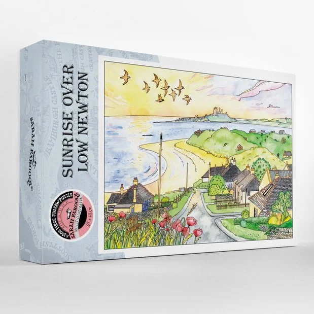 Photo of the box for a 100 piece jigsaw featuring an painting of Low Newton in Northumberland by Sarah Farooqi