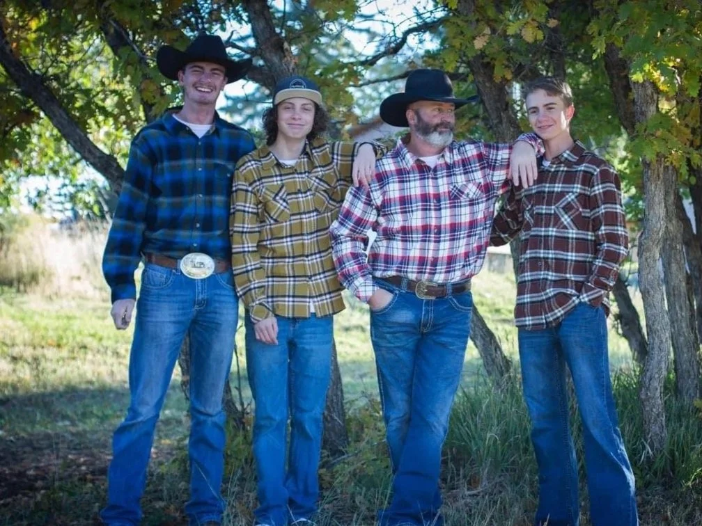 MCD board member Walter standing with his 3 sons in front of nature