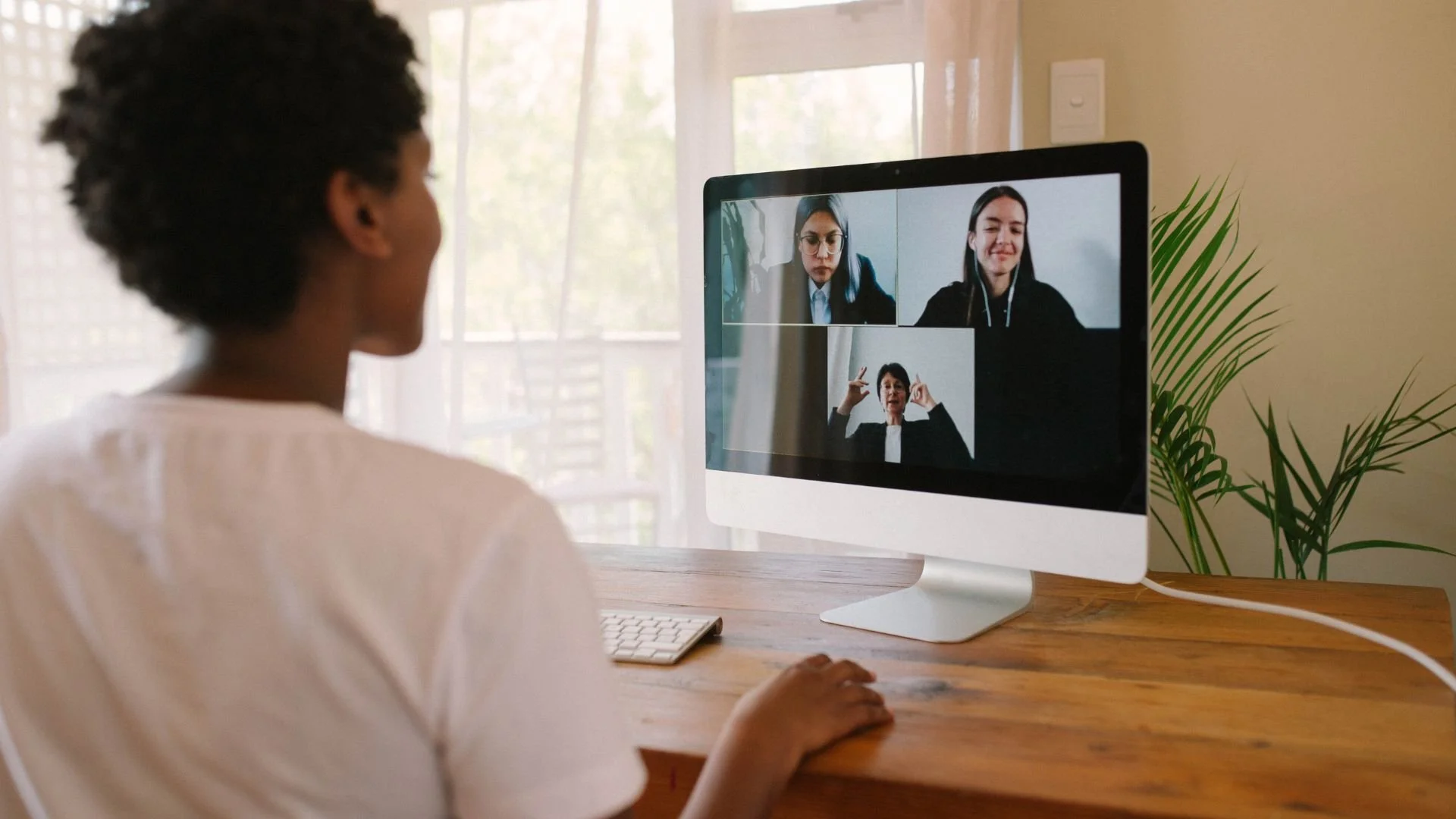 Woman participating in a Zoom call with three other people