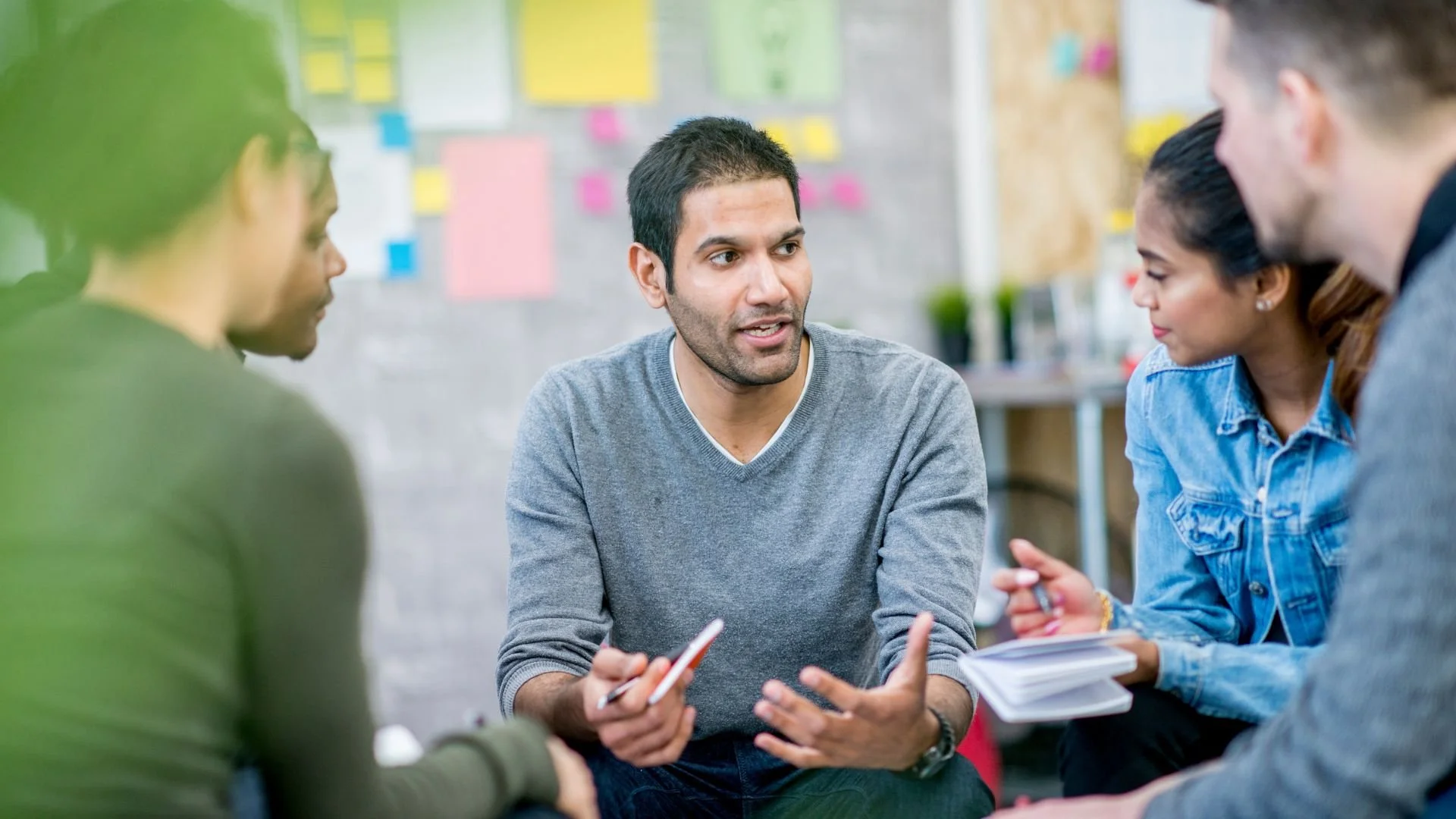 Team members gathered in a circle having a discussion.