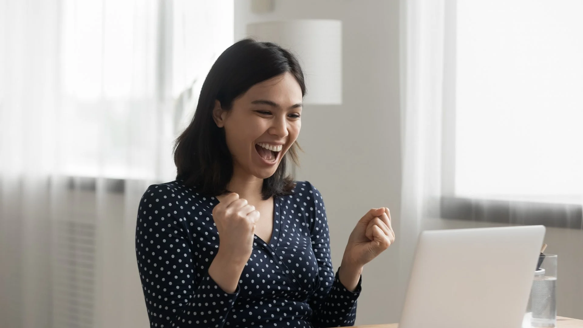 Excited woman reacting to improved results from a nonprofit re-engagement email campaign.