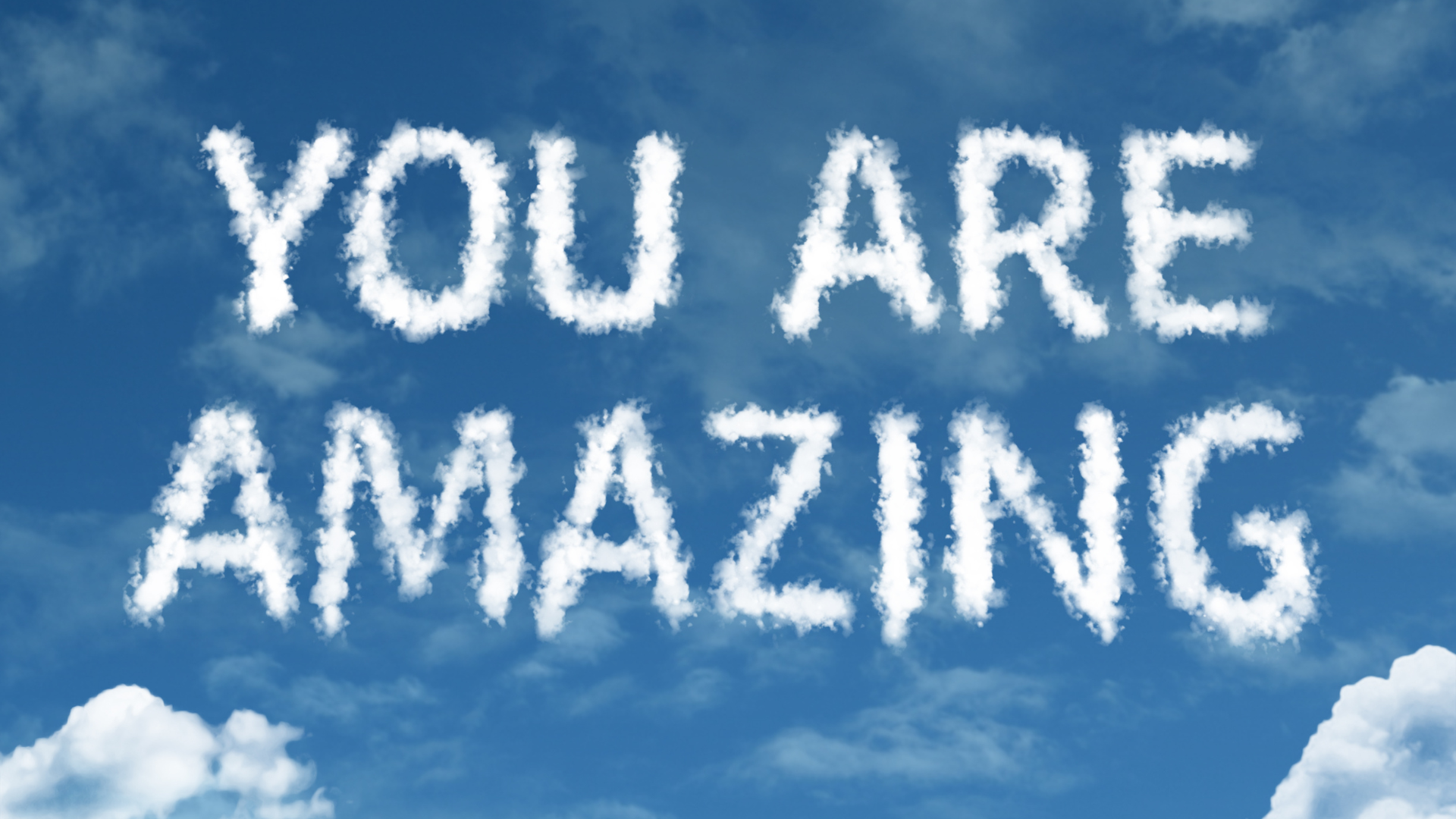 The words "YOU ARE AMAZING" written in cloud-shaped letters against a blue sky