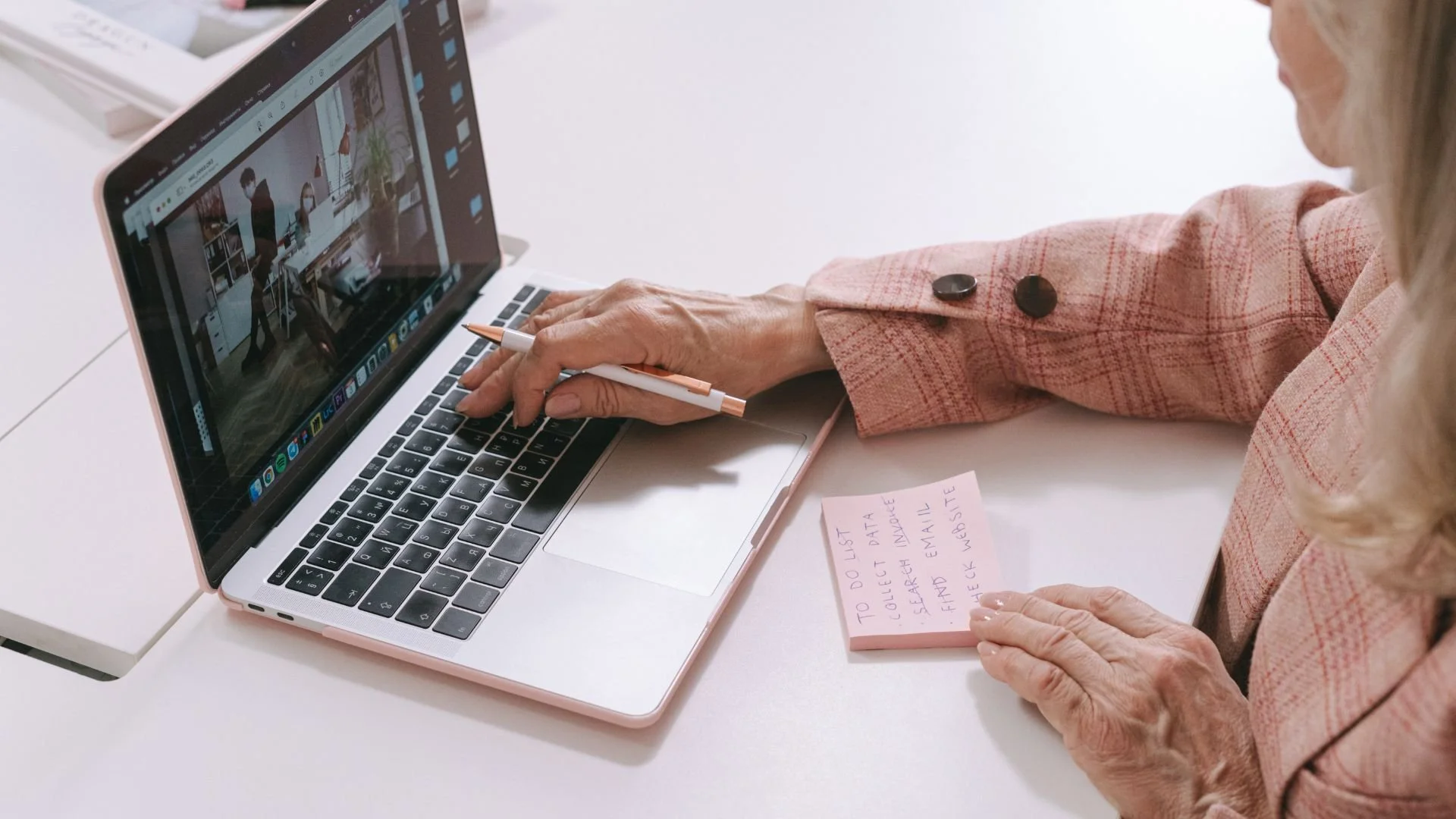 Woman at a laptop making a to do list on a post-it