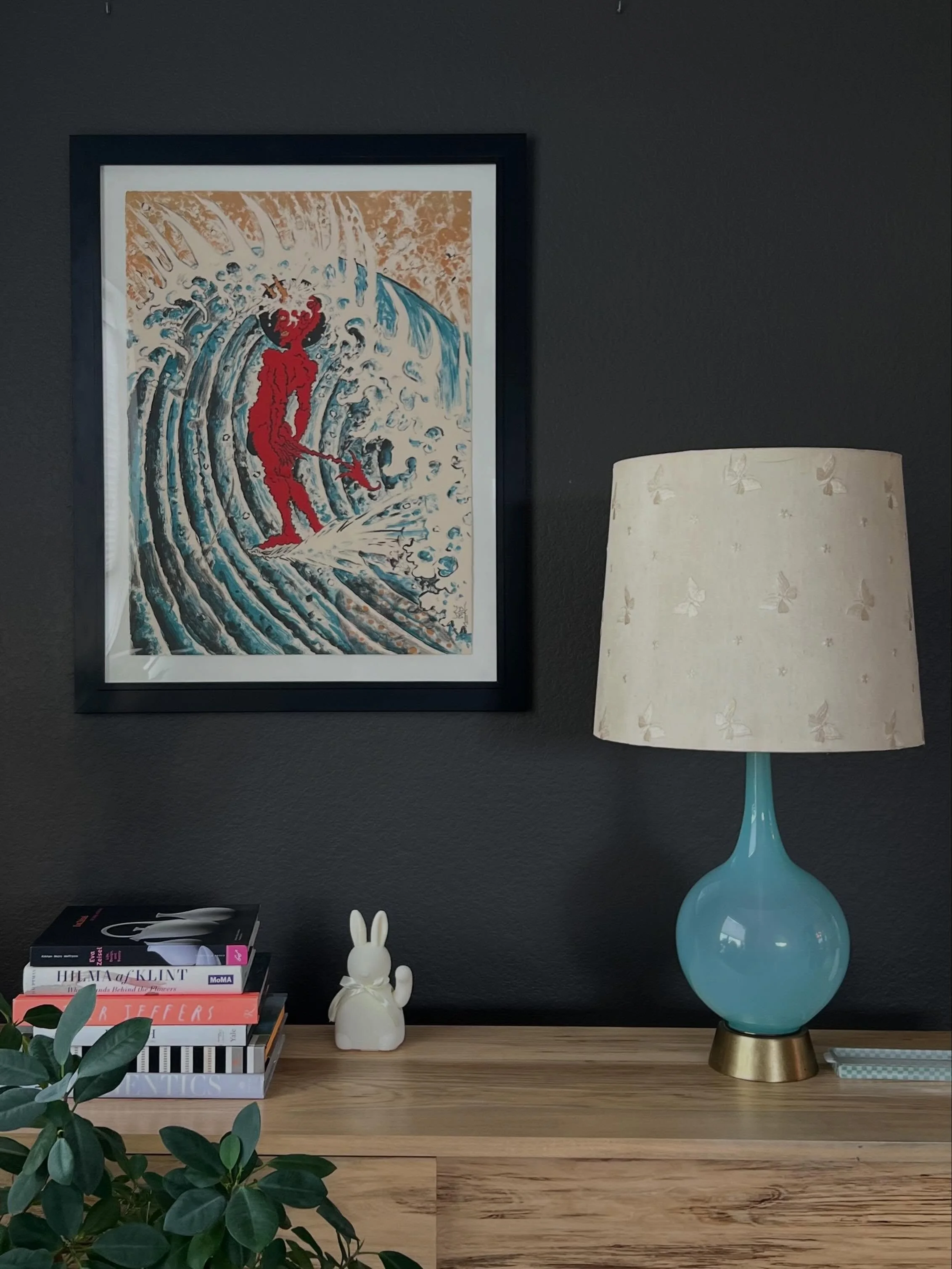 I like creating vignettes with art. This Don Ed Hardy &ldquo;Devil Surfer,&rdquo; feels good with our waving bunny and butterfly lampshade. Friction is a beautiful thing.
.
.
.
#art #artoninstagram #artistsoninstagram #tattooartist #insitu