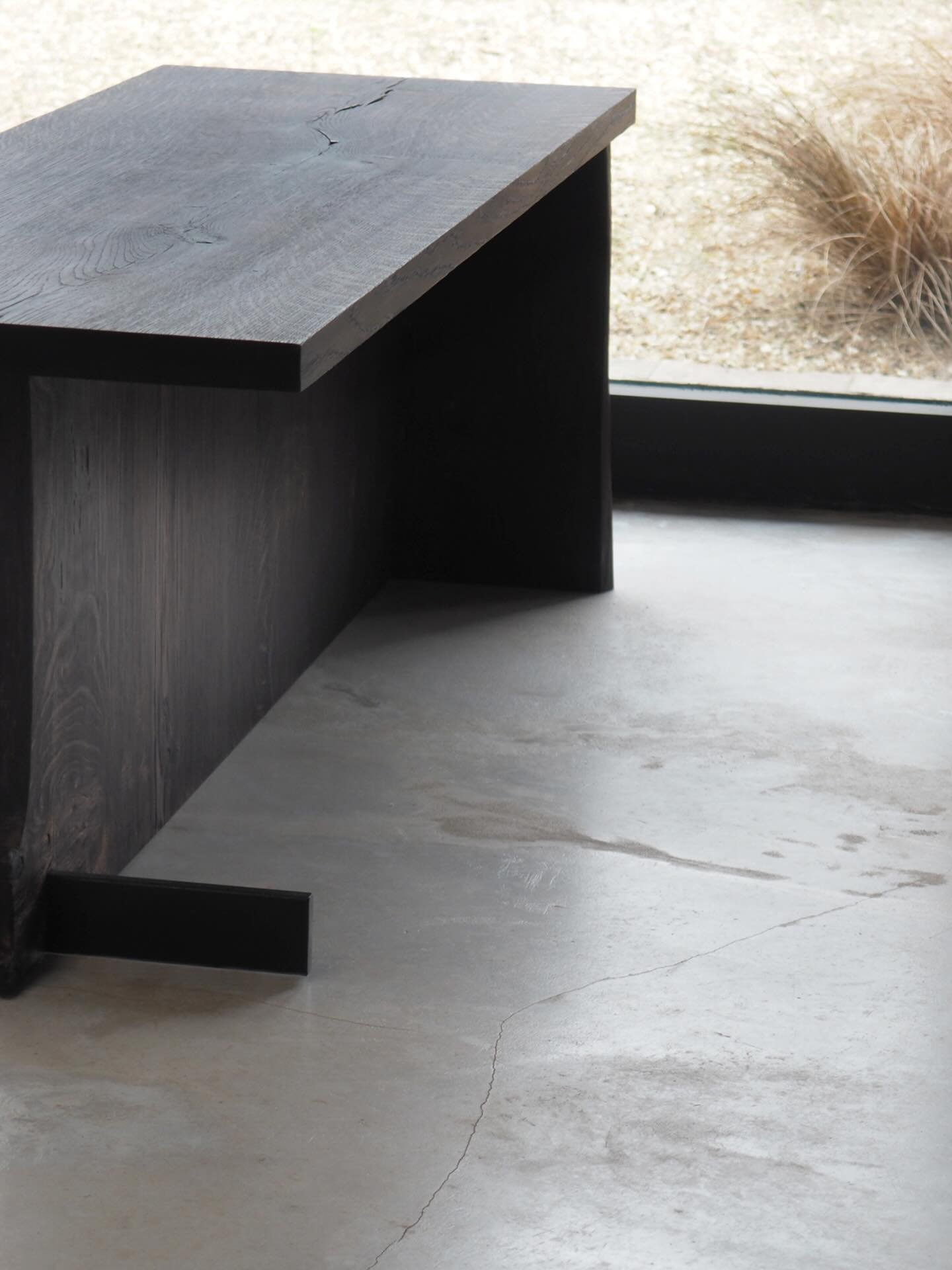 New bench in scorched English Oak, based on our natural edged oak stools.
We lightly scorched the oak on this piece to achieve a rich dark brown tone, which contrasts beautifully with the black steel bar that cuts through the base.
Photographed in ou