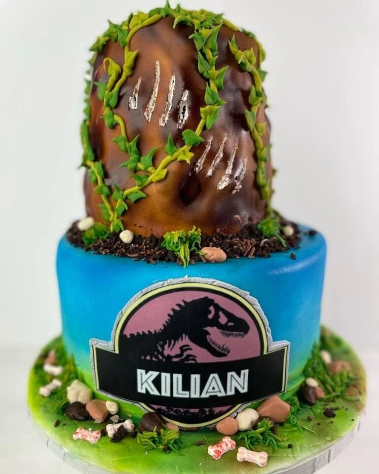 We are getting #Wild and celebrating Kilian with this amazing #Jurassic Park themed cake. This cake has two flavors.  The top tier, is a mountain made of chocolate cake with vanilla buttercream, and the bottom tier is vanilla cake with Oreo cookies a