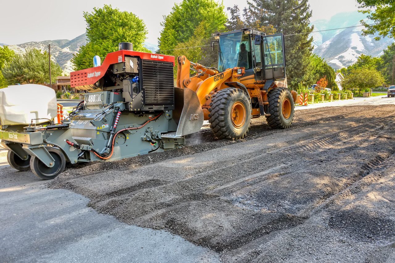 Recycled asphalt millings being spread and compacted for road construction and paving