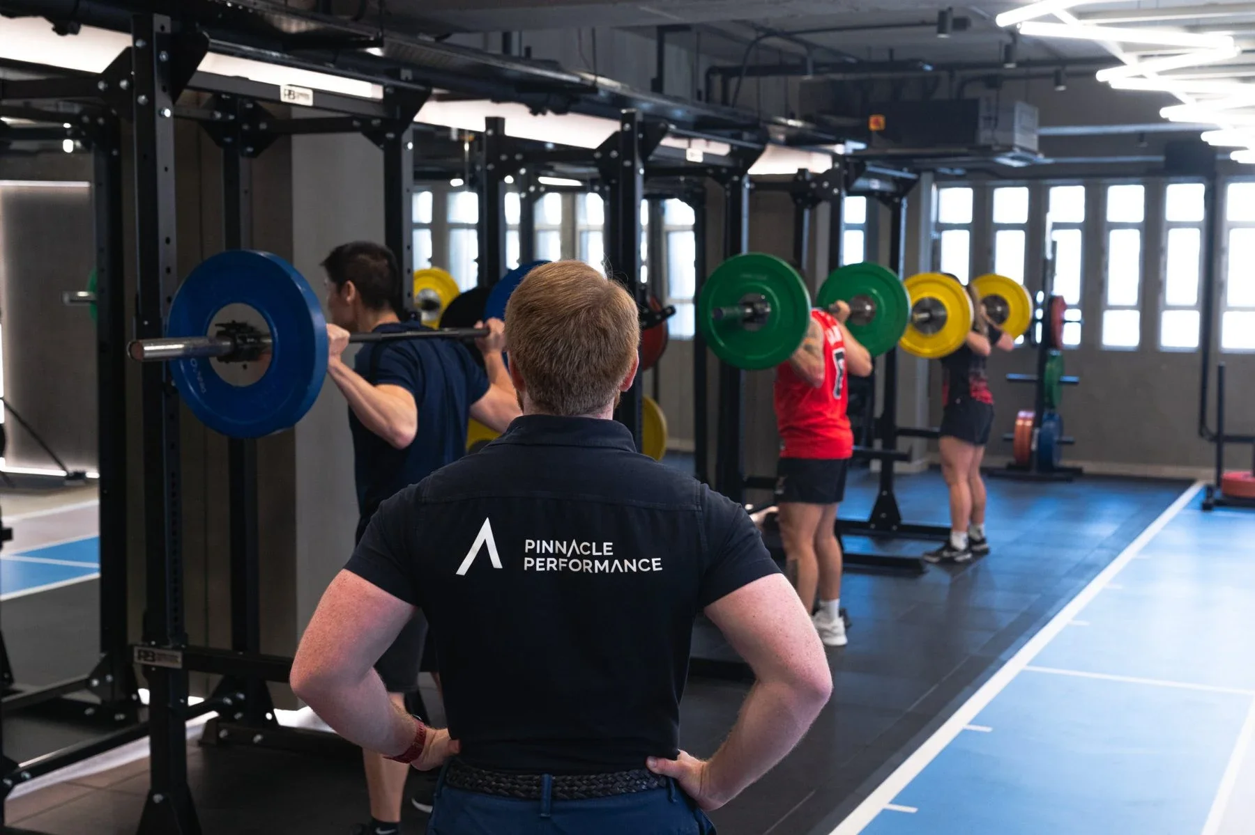 A Pinnacle coach supporting squat training at the Central facility