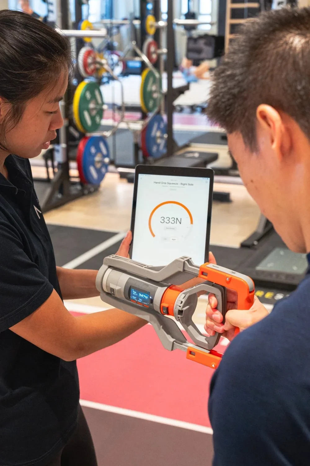A Pinnacle coach carrying out a grip strength test with a tablet
