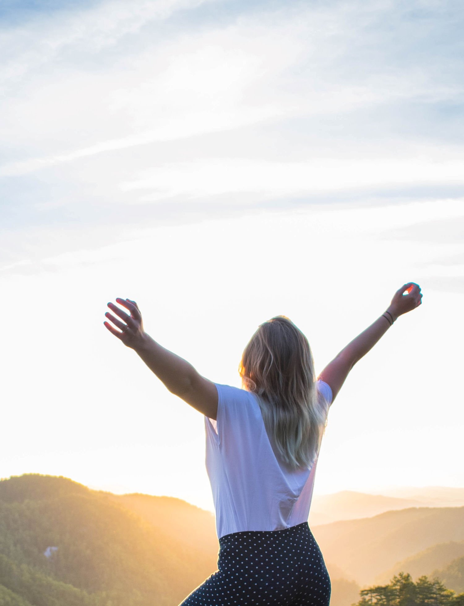 A woman with her hands outstretched to the sky