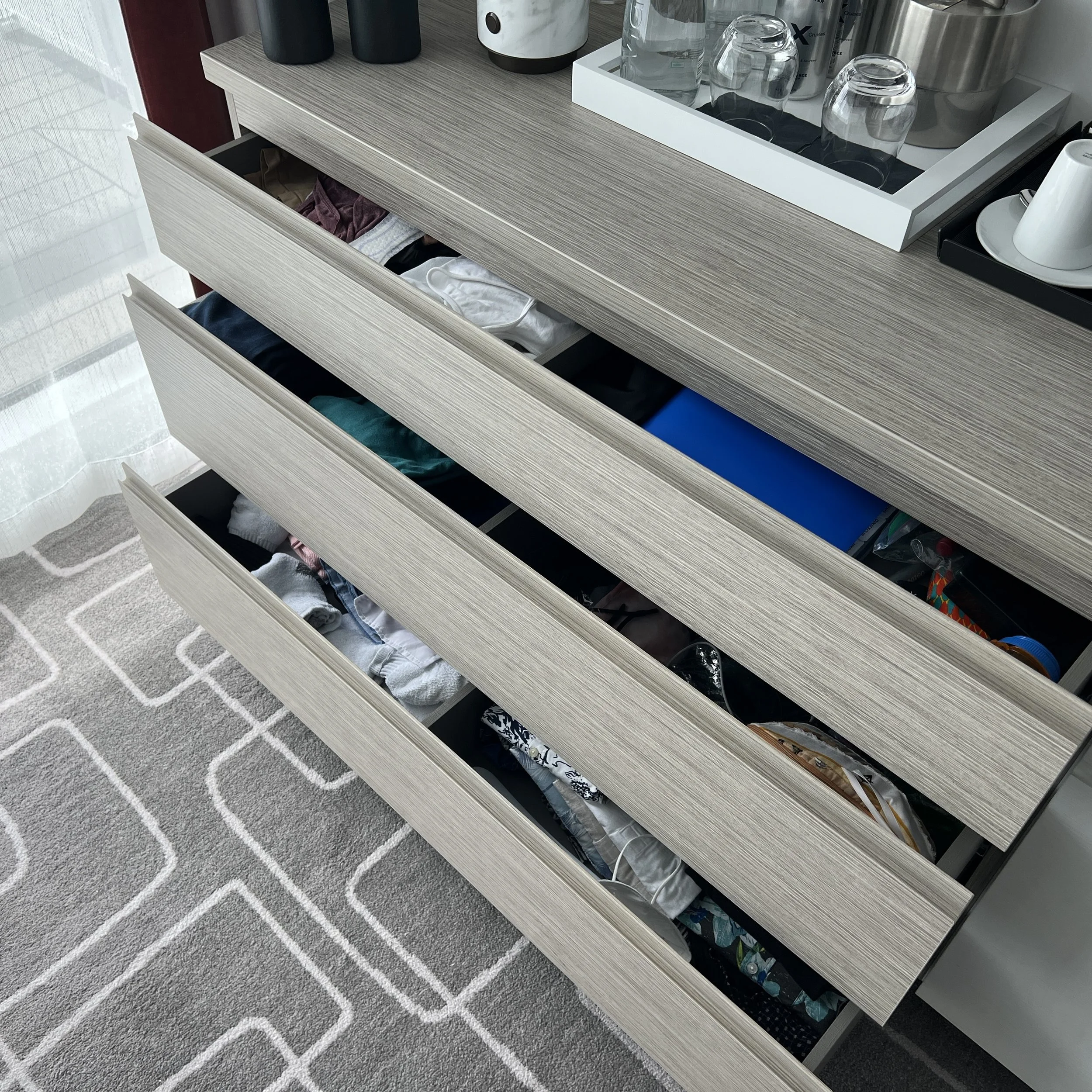 The chest of drawers has three drawers that are left open slightly to reveal the cruiser's clothing inside. Each drawer is divided into two parts.