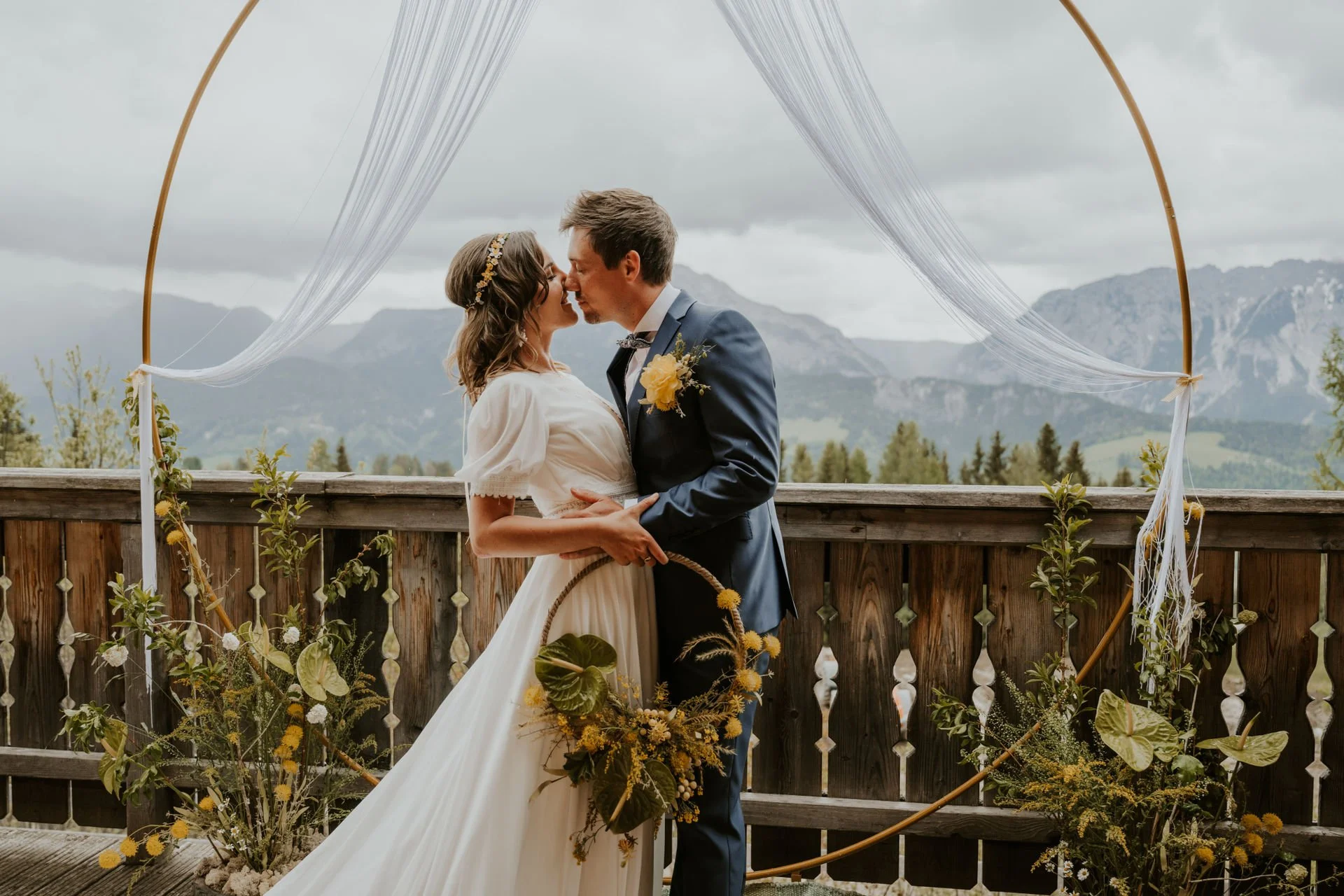 Brautpaar vor großem Traubogen