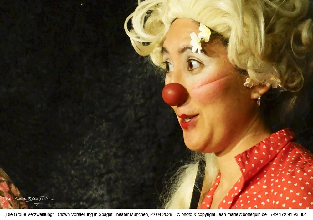 Man sieht Nahirs Clown Kopf mit roter Nase und Blümchen unter der Perücke