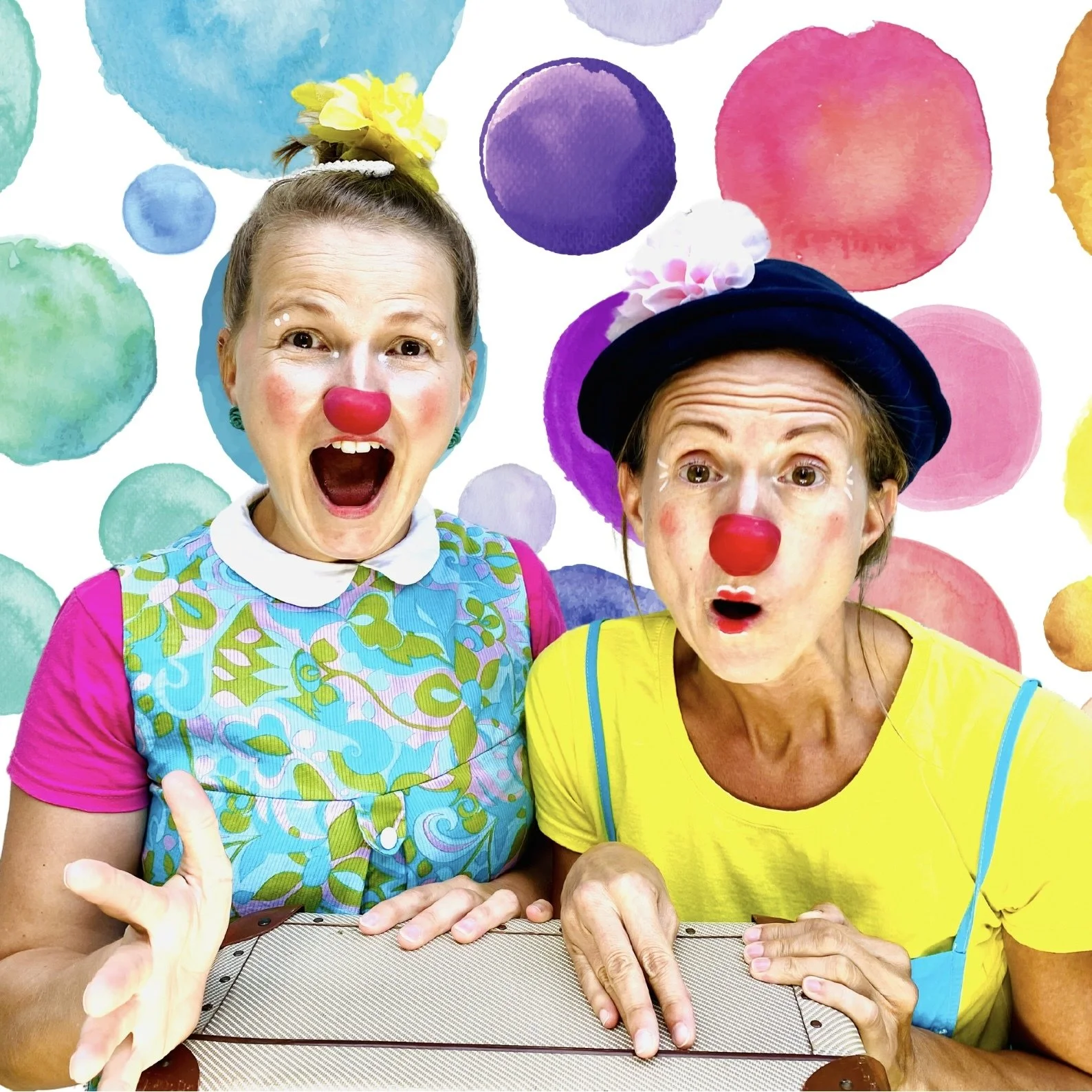 Zwei Clowns mit roten Nasen. Hintergrund bunte Kreise.
