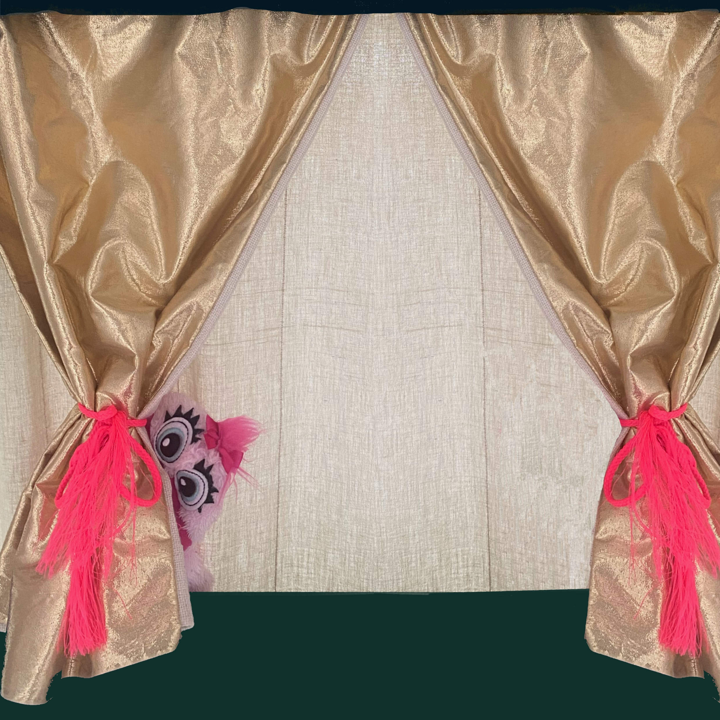 Bühne mit goldenem Vorhang und einer rosa Kasperl versteckt hinter einem der Vorhänge